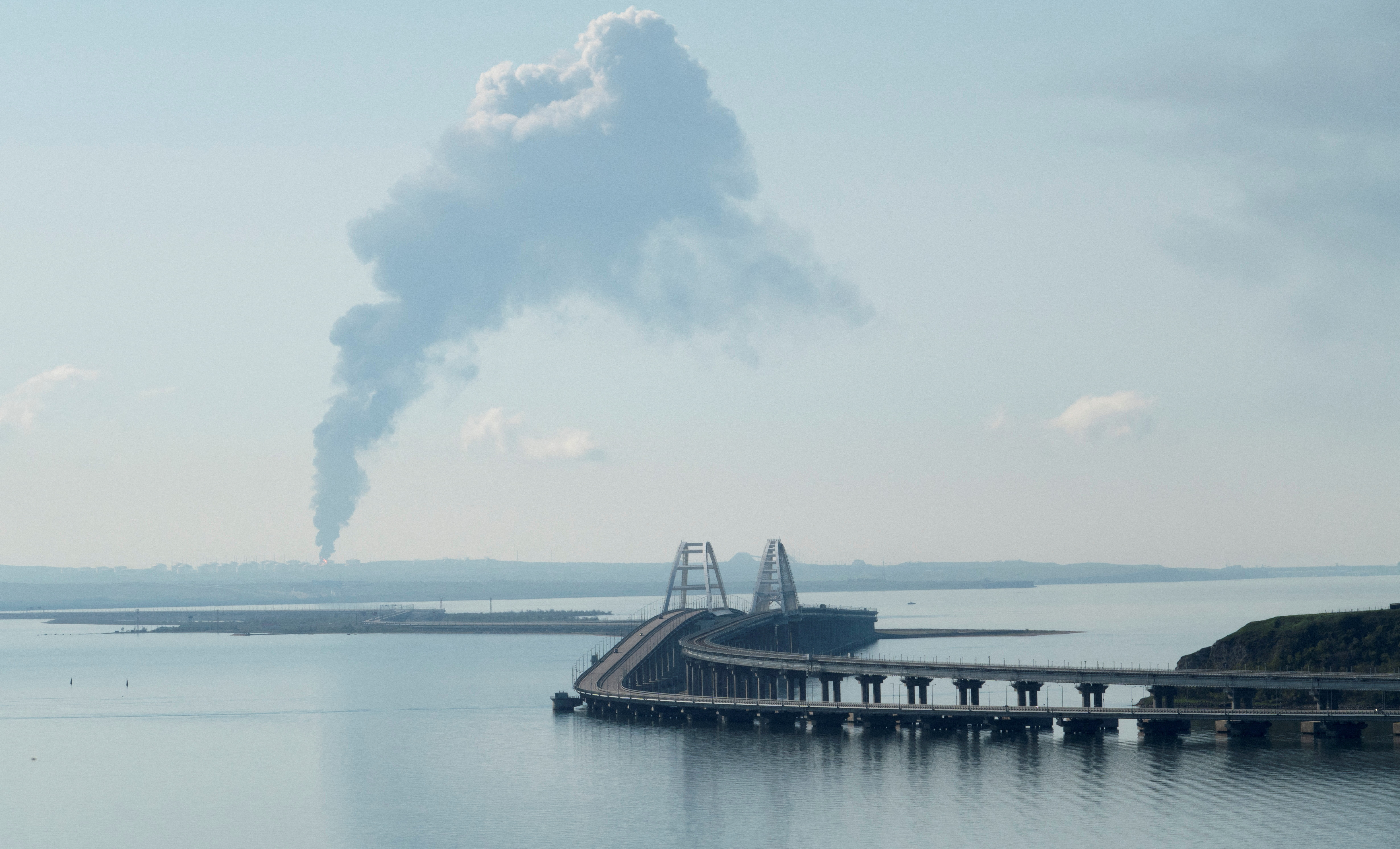 Humo se eleva por encima de un depósito de combustible cerca del puente de Crimea en el pueblo de Volna (REUTERS)
