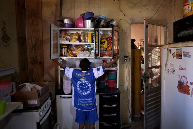 Miguel Barros muestra las donaciones en un armario en su casa en Santa Luzia, un municipio de Belo Horizonte (AFP)