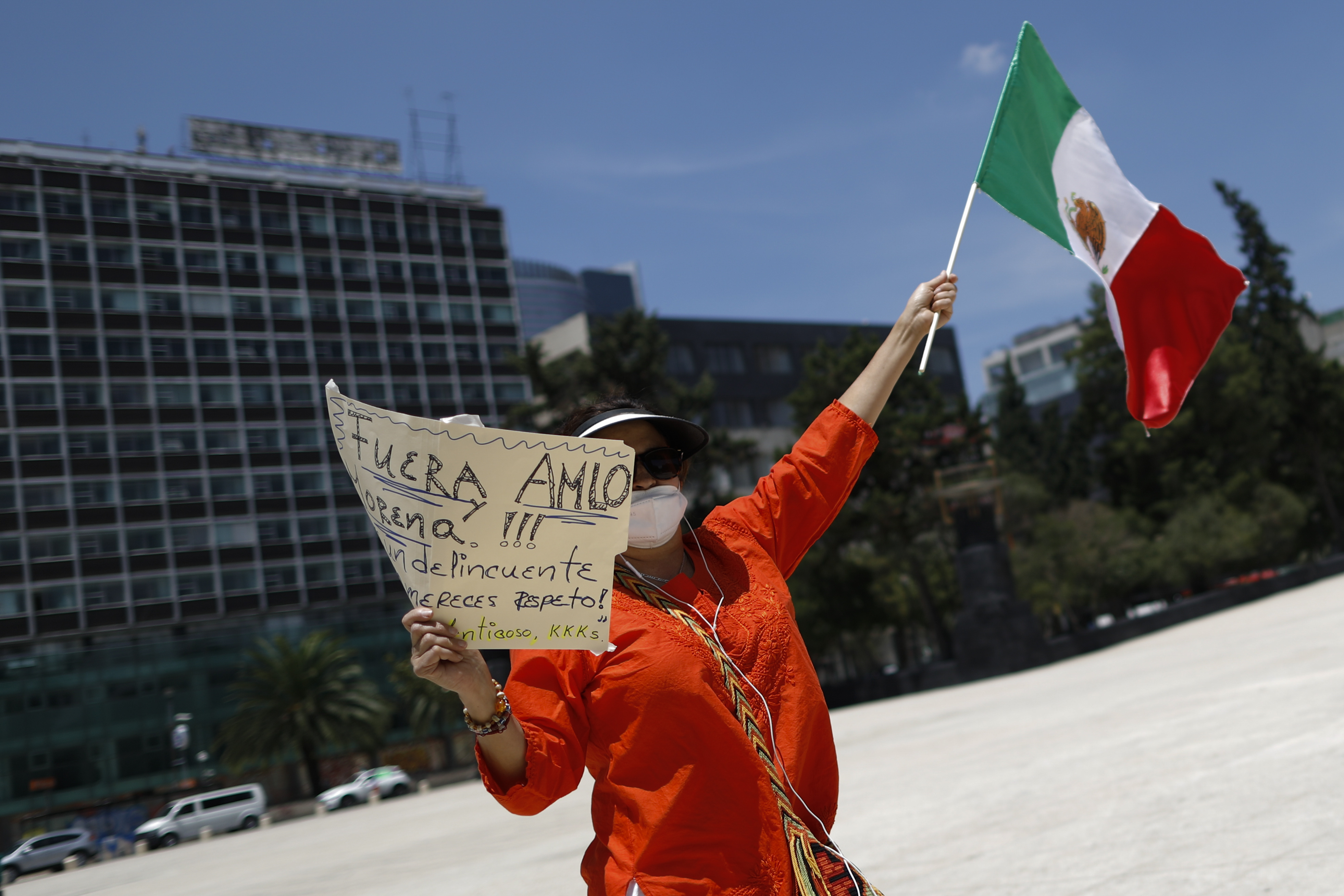 Un manifestante sostiene un cartel que pide la renuncia del presidente Andrés Manuel López Obrador, durante una protesta contra el gobierno por parte de cientos de automóviles, en la Ciudad de México, el domingo 28 de junio de 2020. (Foto AP / Rebecca Blackwell)