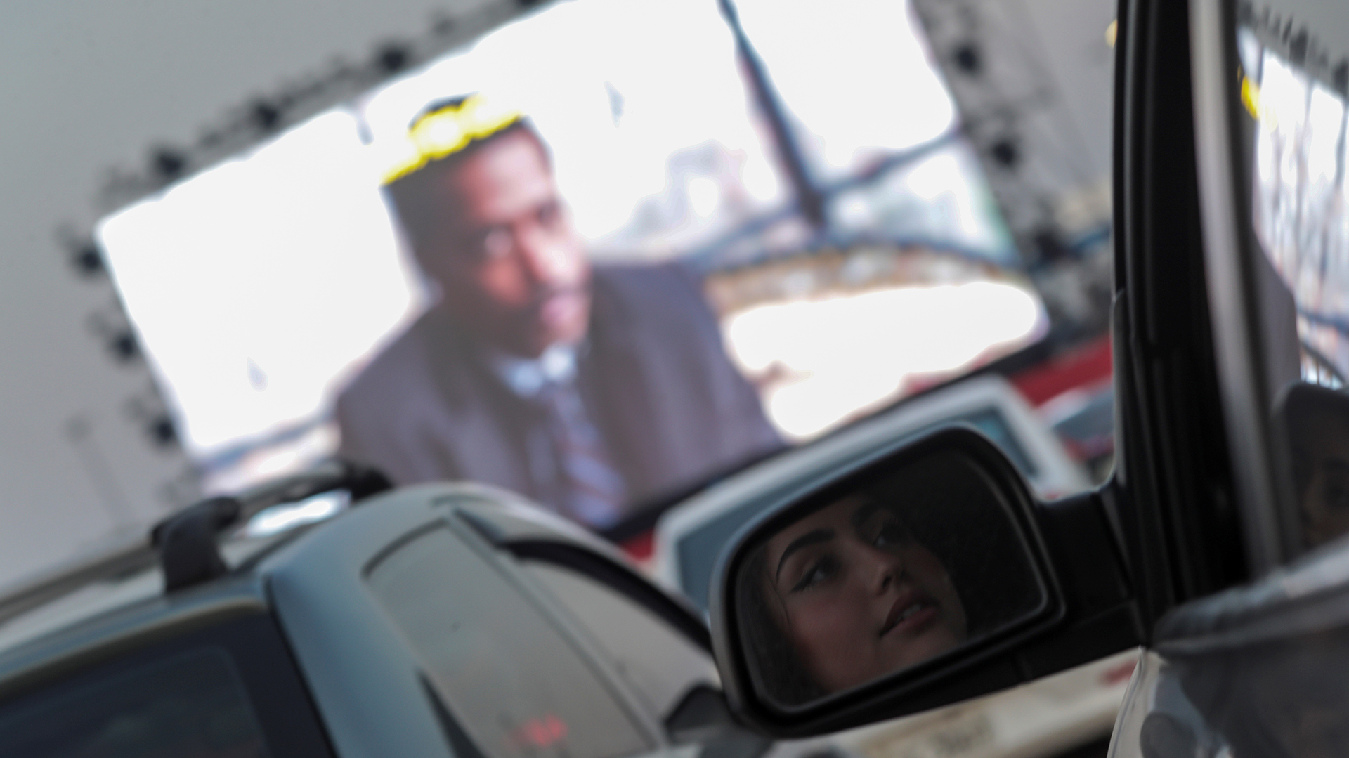 Una mujer observa desde un auto una película en el Love Cine Drive-in Theater ubicado en el estacionamiento del Jeunesse Arena, que era parte del Parque Olímpico Río 2016 (EFE/Antonio Lacerda)
