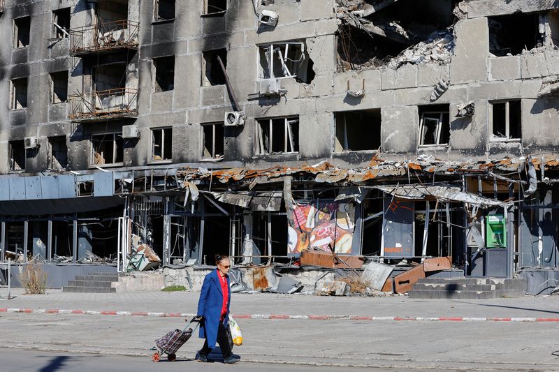 Un cittadino locale passa davanti a un condominio danneggiato durante l'invasione russa dell'Ucraina a Mariupol, in Ucraina (Reuters/Alexander Ermoshenko)