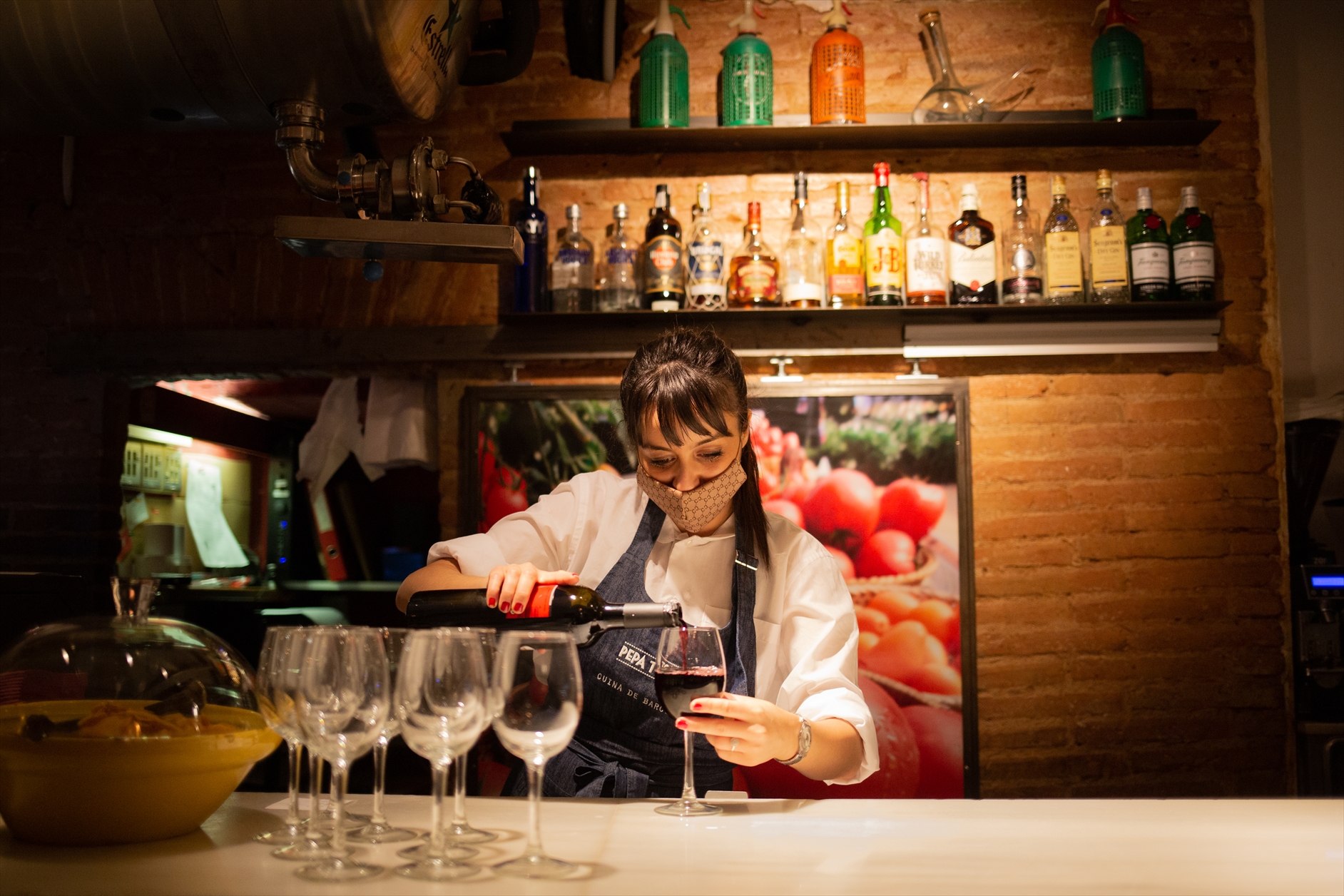 Una camarera sirve una copa de vino en el interior de un bar en una calle céntrica de Barcelona (David Zorrakino - Europa Press)