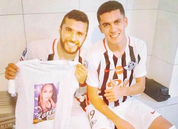VESTUARIO. El delantero en el vestuario liberteño, con la remera con el rostro de Karen y en compañía de un compañero de equipo.