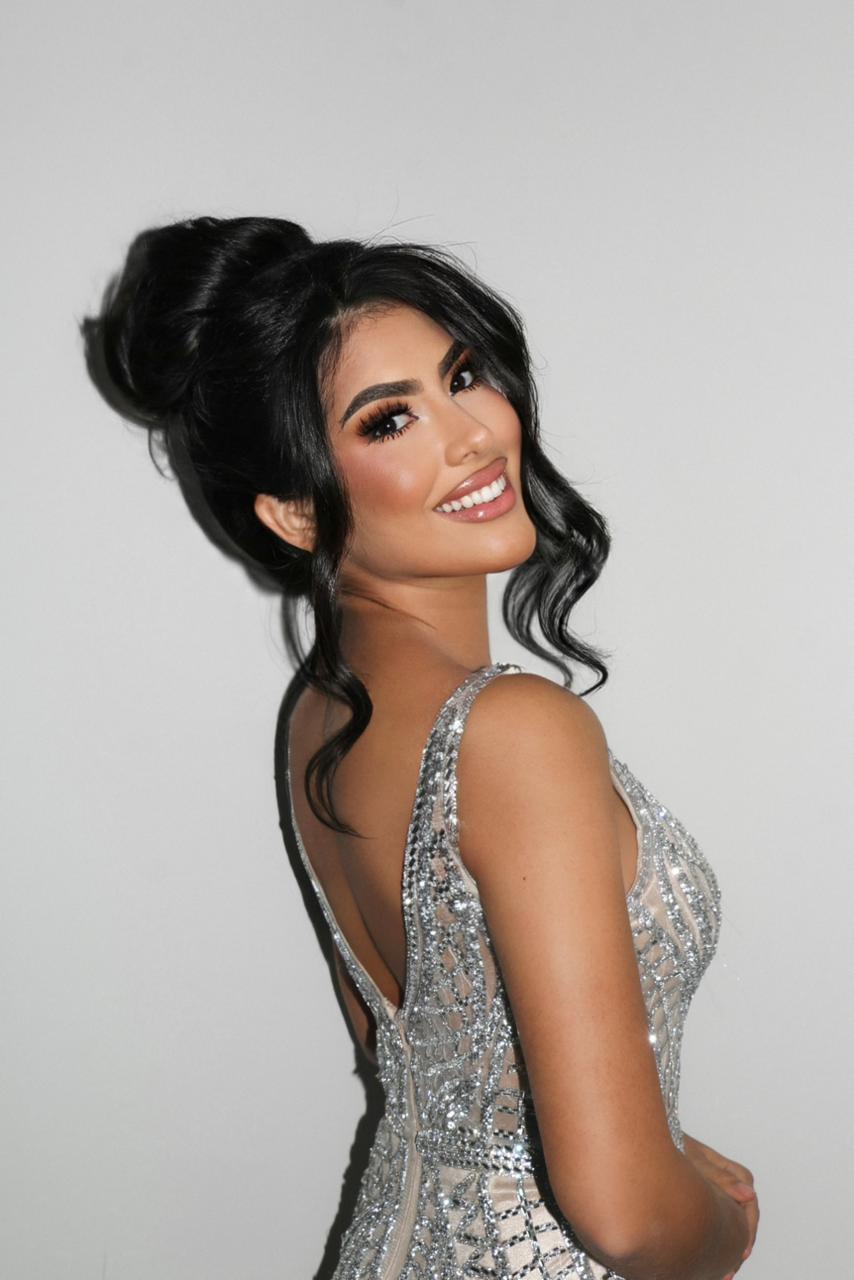 Rivas luce un elegante vestido plateado, un recogido suave y un maquillaje glam.