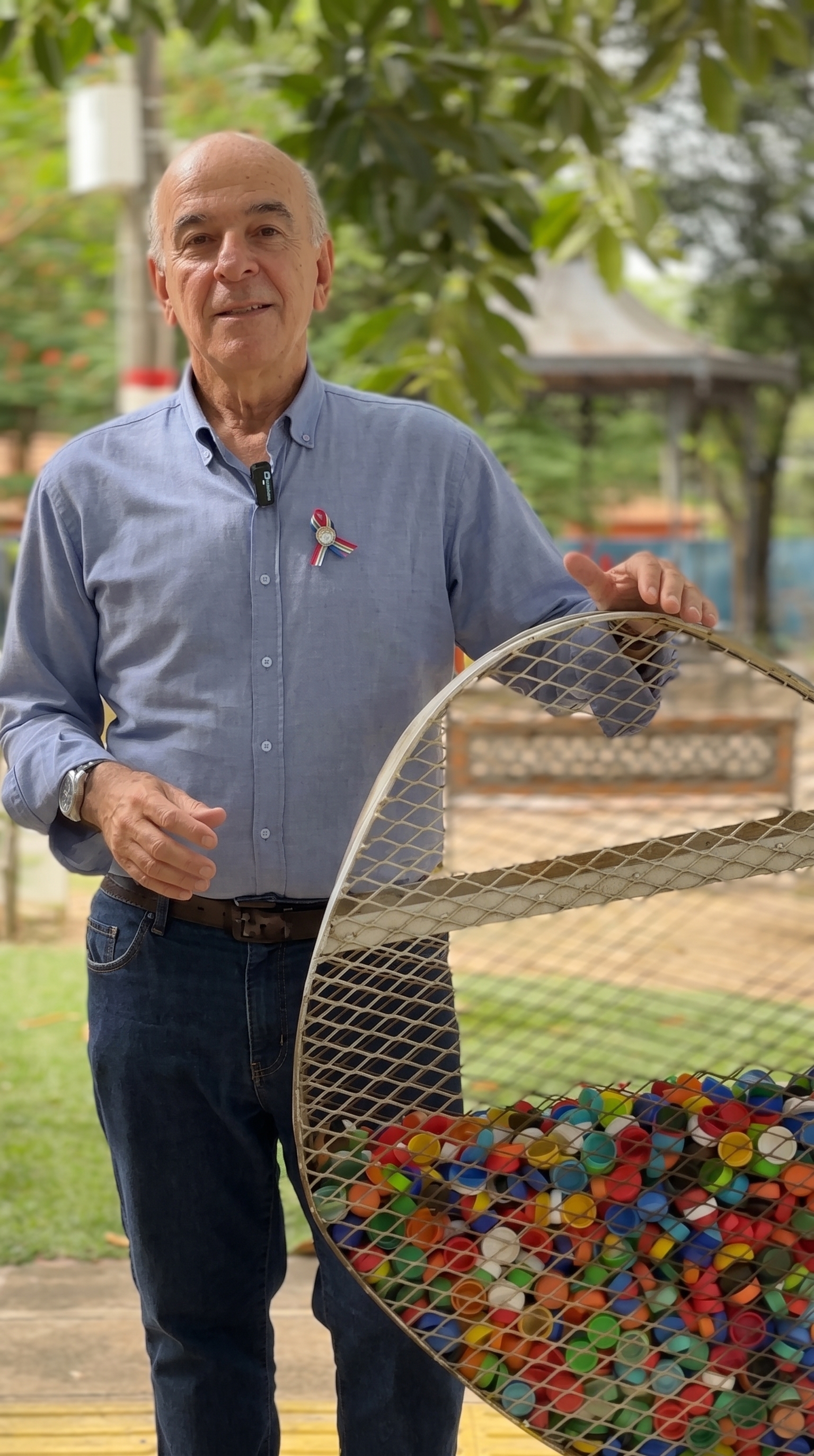 Pequeñas acciones, grandes resultados. El doctor Luis López junto a un contenedor de tapitas en la plaza local, reflejo de su compromiso por llevar la educación ambiental a cada rincón de la comunidad.