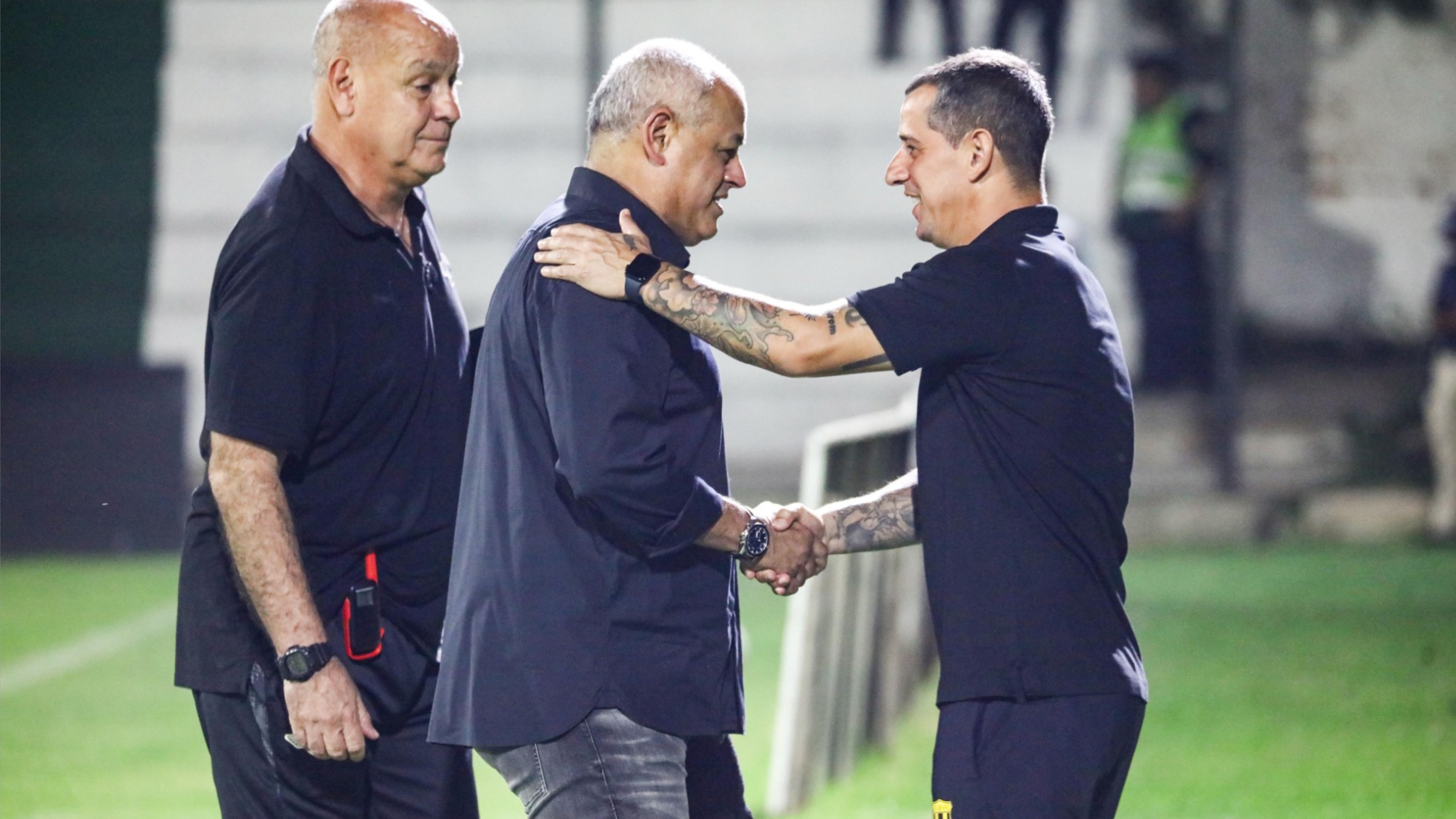 El saludo de los entrenadores, Arce por el lado de Libertad y Romagnoli en Guaraní.