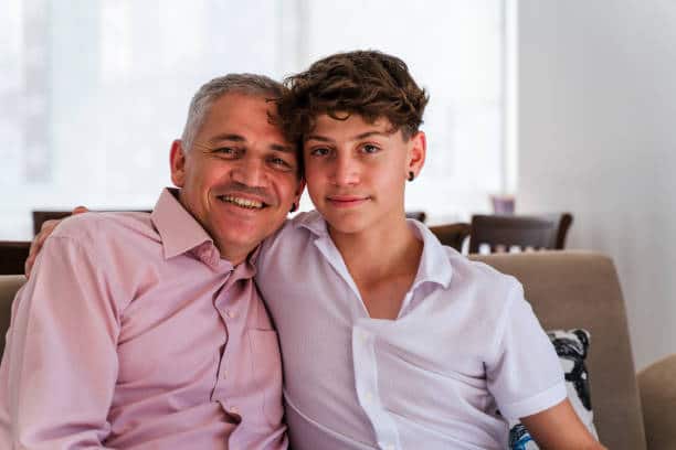 Portrait of father and son in a living room.