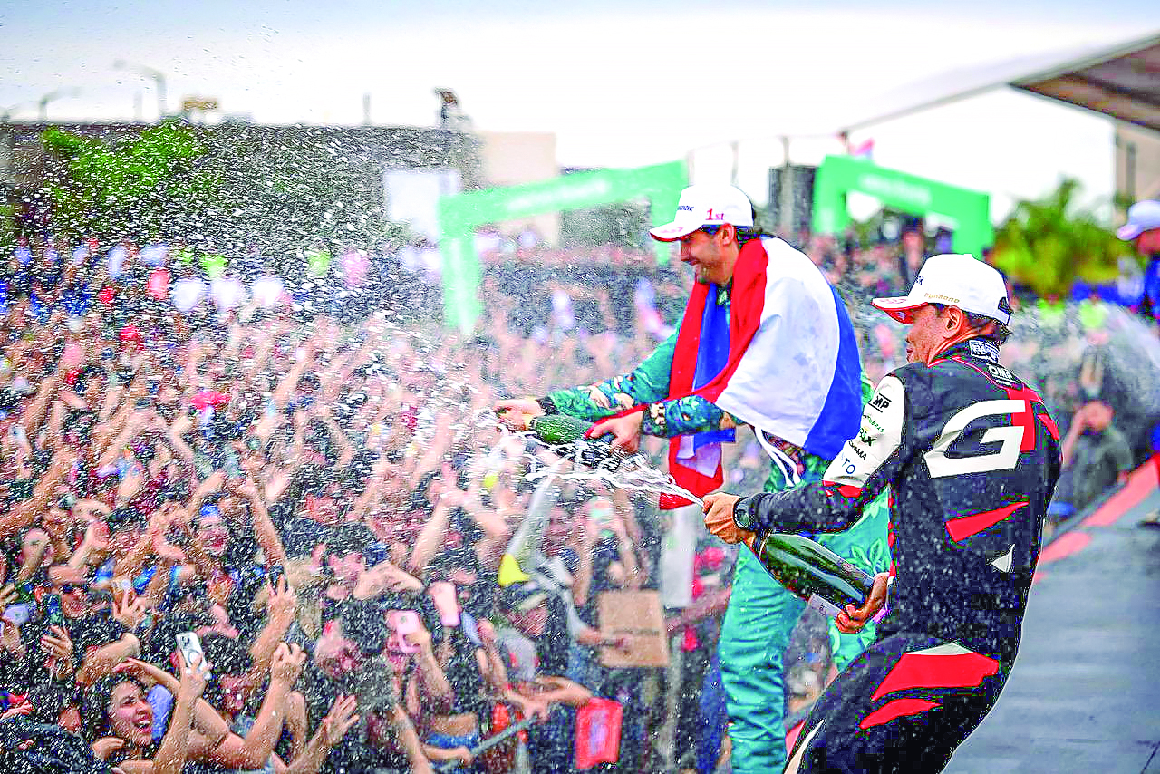 Festejo con la gente. Diego celebró su victoria en la RC2 con la bandera paraguaya al cuello.