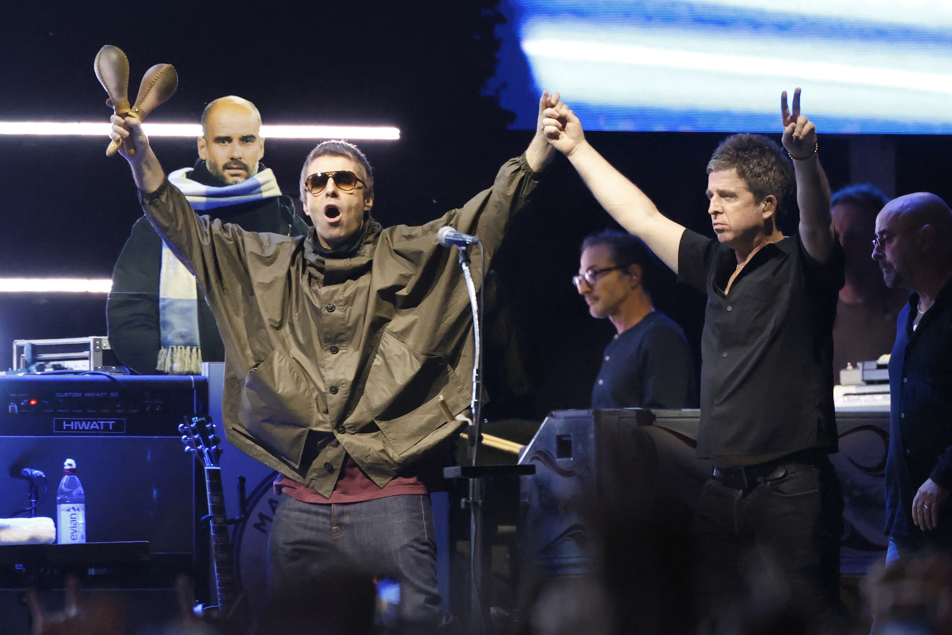 Members of British rock band Oasis, including Liam Gallagher and Noel Gallagher, arrive on stage at Soldier Field in Chicago on August 28, 2025, during their reunion tour. British rock legends Oasis kicked off the North American leg of their blockbuster reunion tour in Toronto on August 24 as ecstatic Canadian fans flocked to their first chance to see the band since 2008. (Photo by KAMIL KRZACZYNSKI / AFP)