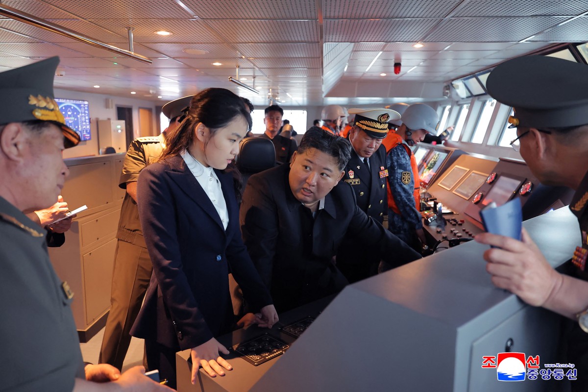 El presidente de Norcorea, Kim Jong Un (c) junto a su hija Kim Ju Ae (centro a la izq.) observando el desarrollo de un destructor en un sitio no confirmado por las autoridades de Corea del Norte.
