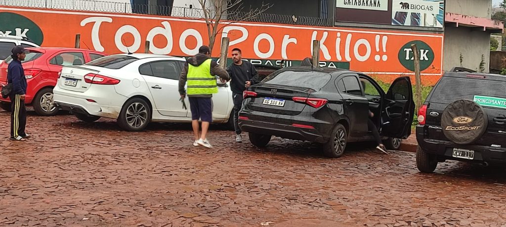 Un turista accede a pagar a un "cuidacoches" por el "servicio" de cuidarle el auto. Una imagen que se repite, e incomoda a turistas y comerciantes.
