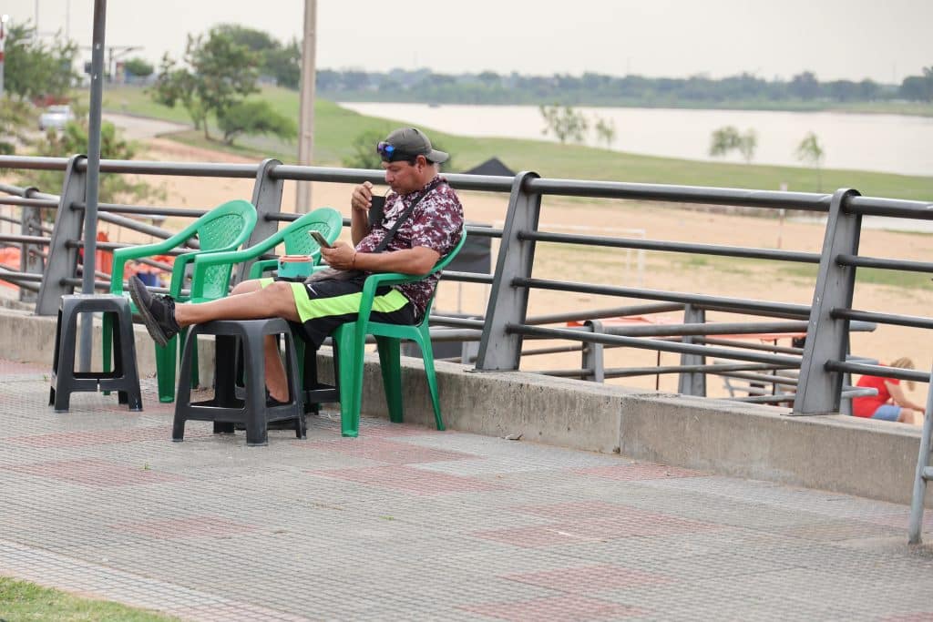 Un hombre se refresca con un tereré para sobrellevar el intenso calor de la Costanera, enAsunción.