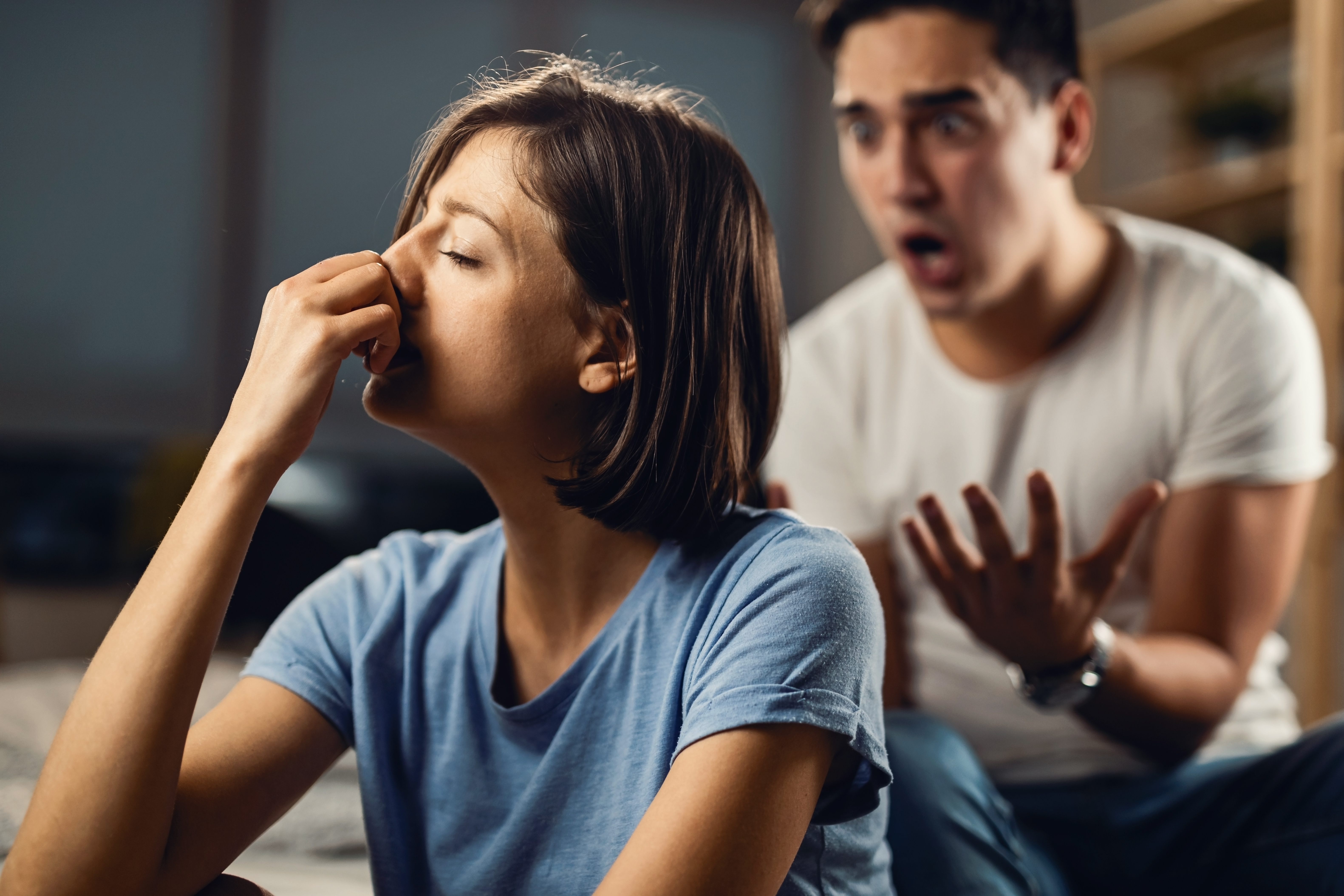 Depressed woman feeling unhappy in a relationship with her boyfriend and ignoring him while he is yelling at her.