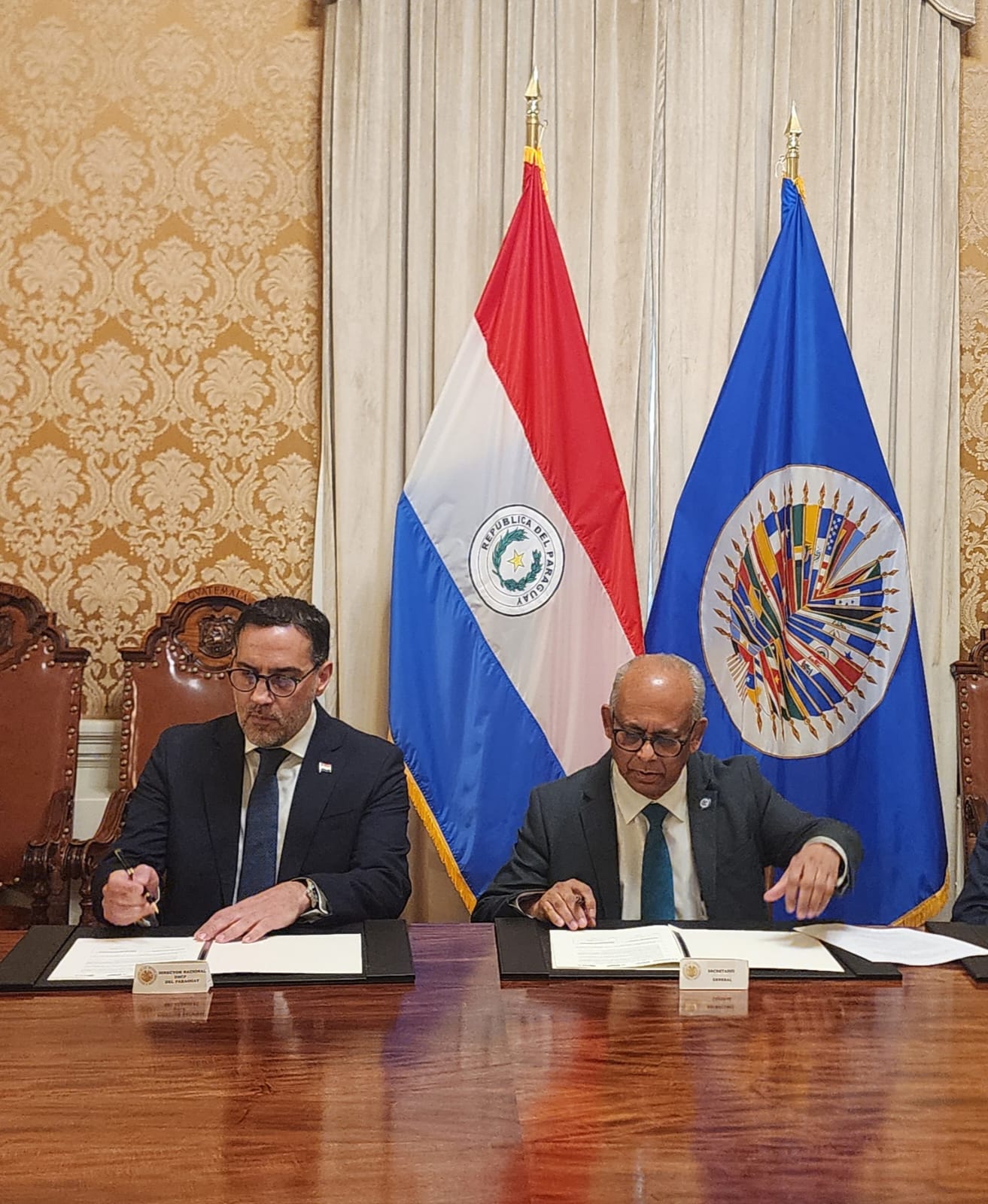 Los firmantes: Juan Agustín María Encina Pérez, titular de la DNCP y el secretario general de la OEA, Albert Ramdin.