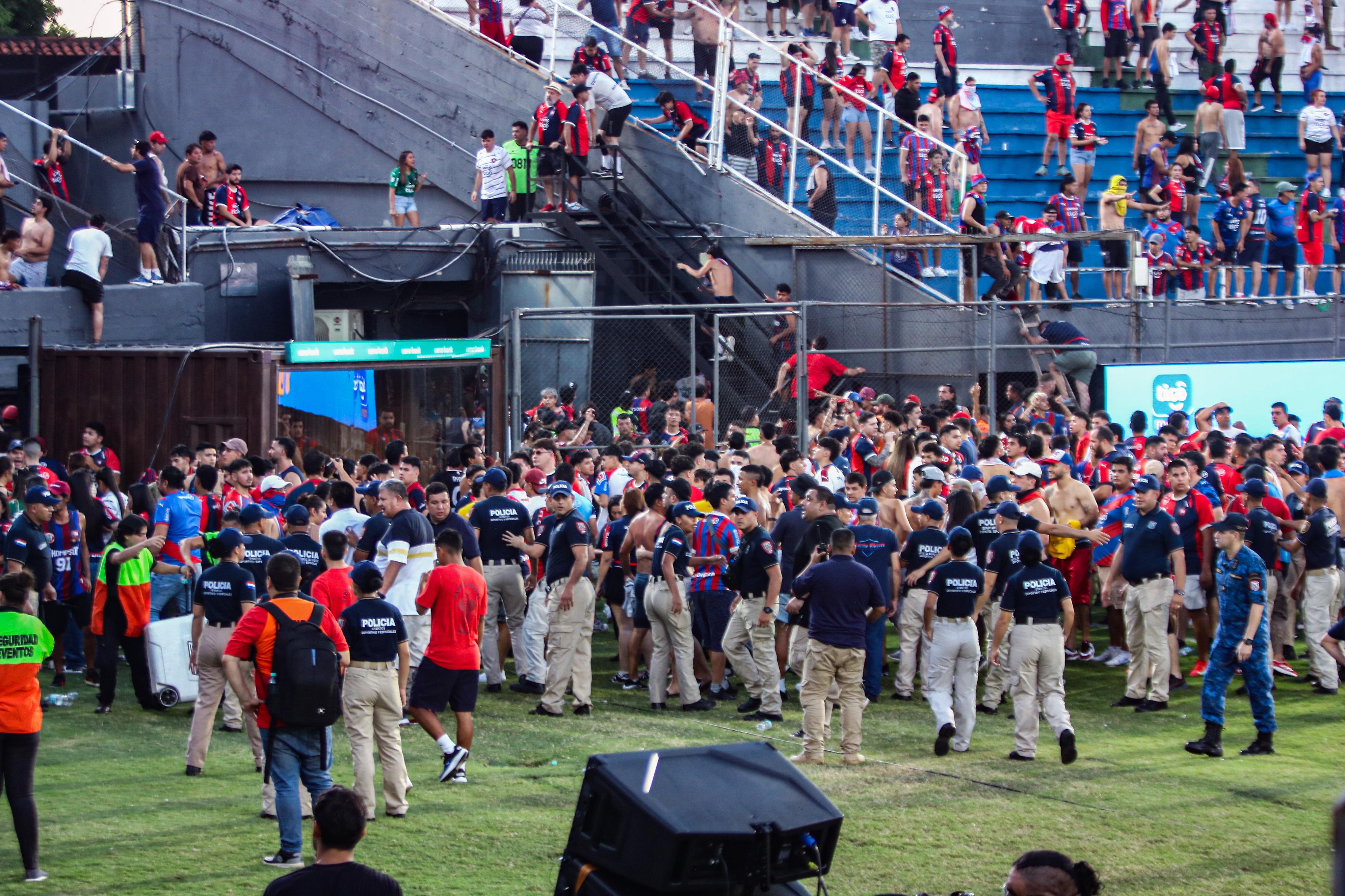Invasión de campo de juego. Huyendo del caos, muchos hinchas pisaron el césped del Defensores del Chaco.