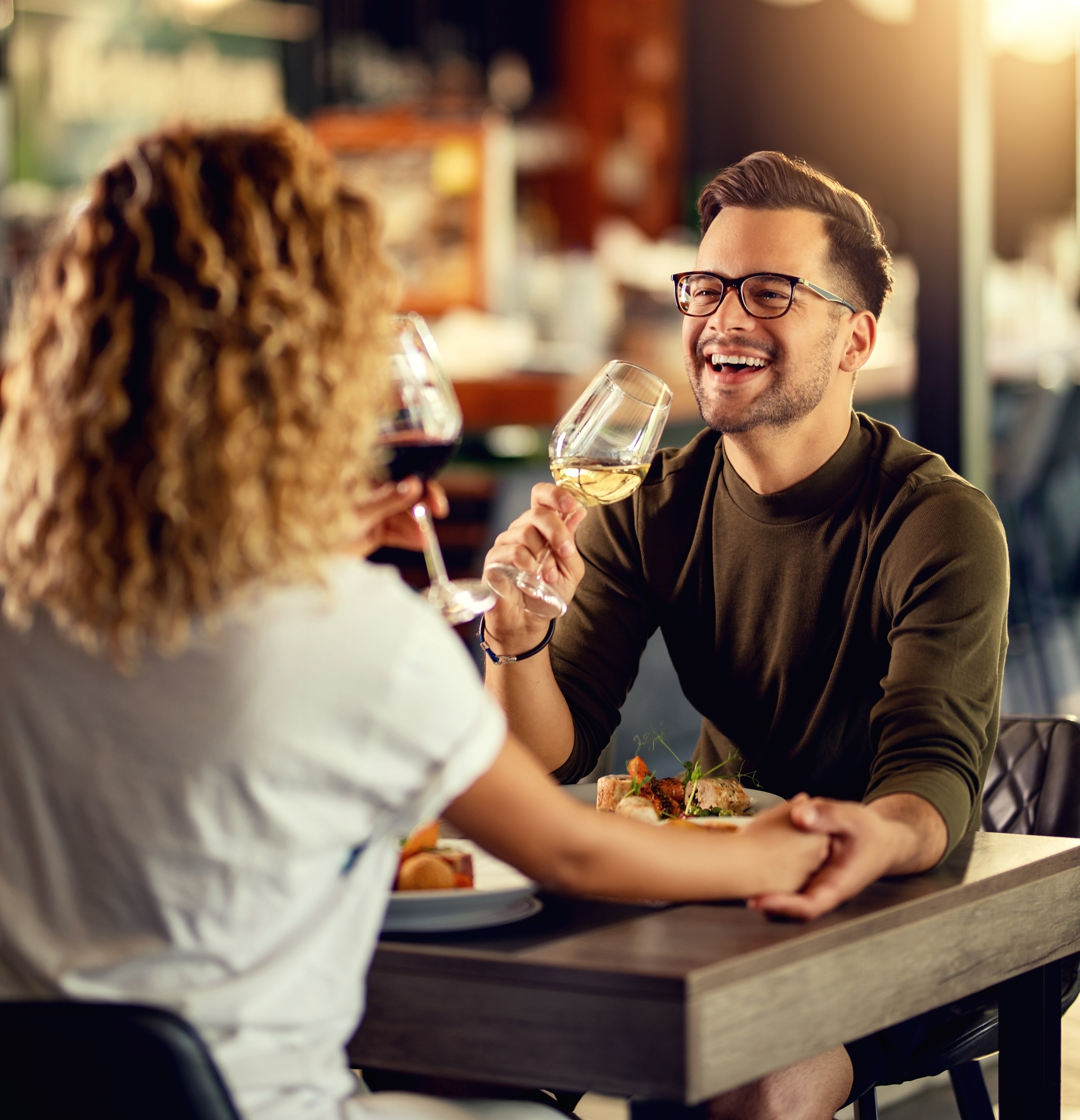Cheerful man having fun while drinking wine with his girlfriend in a restaurant.