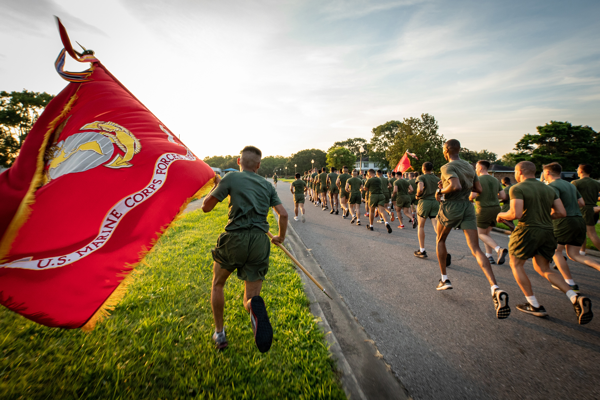 A U.S. Marine runs with the Marine Corps Forces South guidon during a formation run around Marine Corps Support Facility New Orleans on June 15, 2021. (Cpl. James Stanfield/Marine Corps)