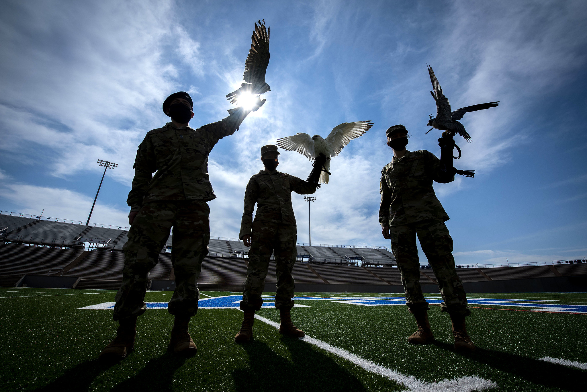 Cadet 2nd Class Kayla Steiner, center, handler of Nova, the newly named 15-week-old full white-phase Gyrfalcon, displays the new mascot of the U.S. Air Force Academy with Cadet 1st Class Seamus Kean, left, and Cadet 3rd Class Sierra Hillard, right. (Joshua Armstrong/Air Force)
