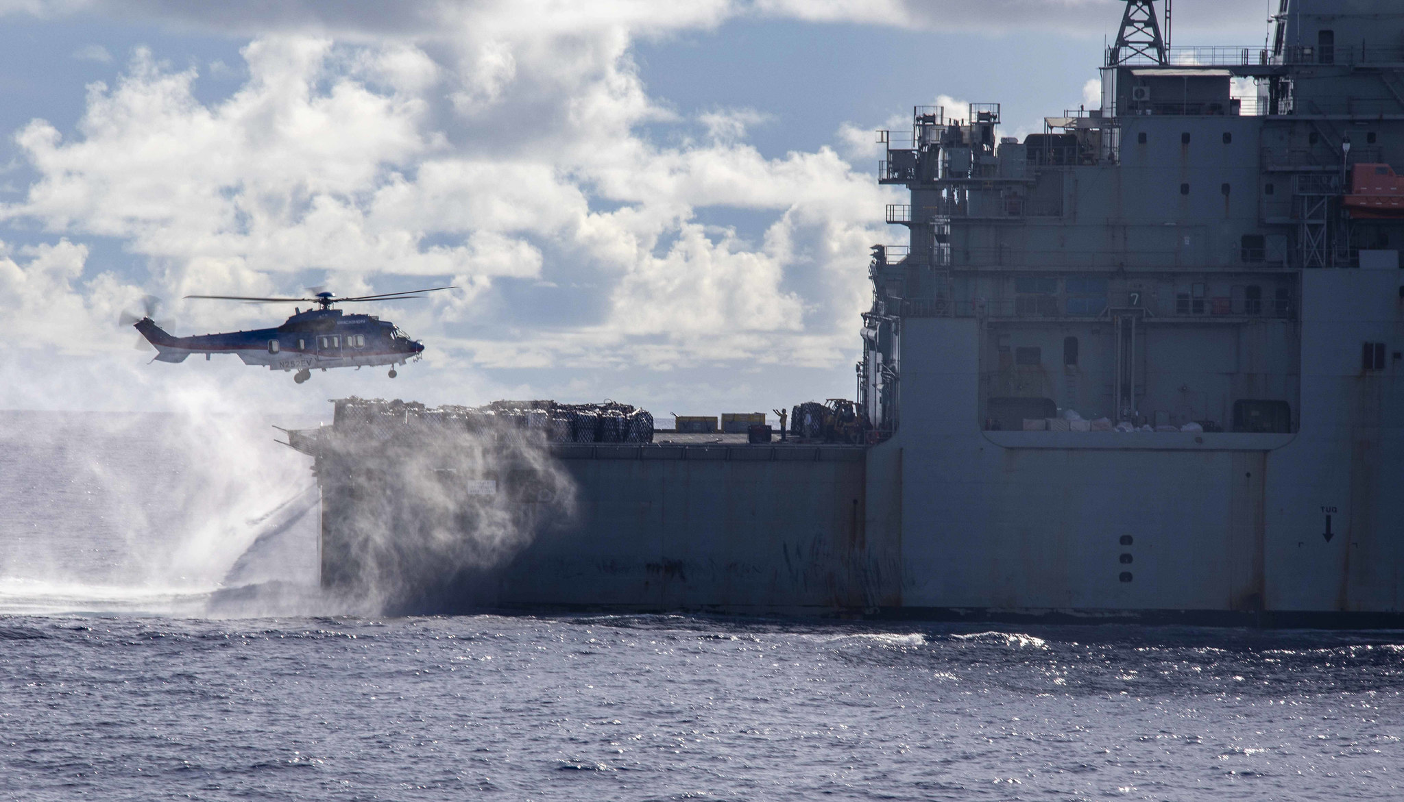 A U.S. Airbus H225 Super Puma helicopter conducts a replenishment-at-sea April 14, 2021, with the dry cargo and ammunition ship USNS Alan Shepard (T-AKE 3) and the amphibious assault ship USS Makin Island (LHD 8) in the Pacific Ocean. (Mass Communication Specialist Seaman Nadia Lund/Navy)