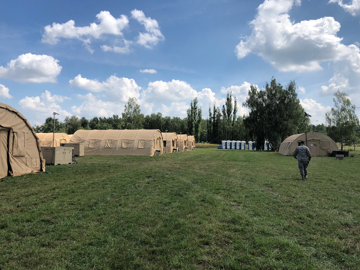 The first-ever DABS proof of concept officially kicked off July 16, when vehicles and supplies started arriving at Poland's 31st Air Base. This photo shows 12 tents used for living quarters, left, with the headquarters of the 1st Combat Communications Squadron, which provided classified and unclassified radio and internet, right. (Valerie Insinna/Staff)