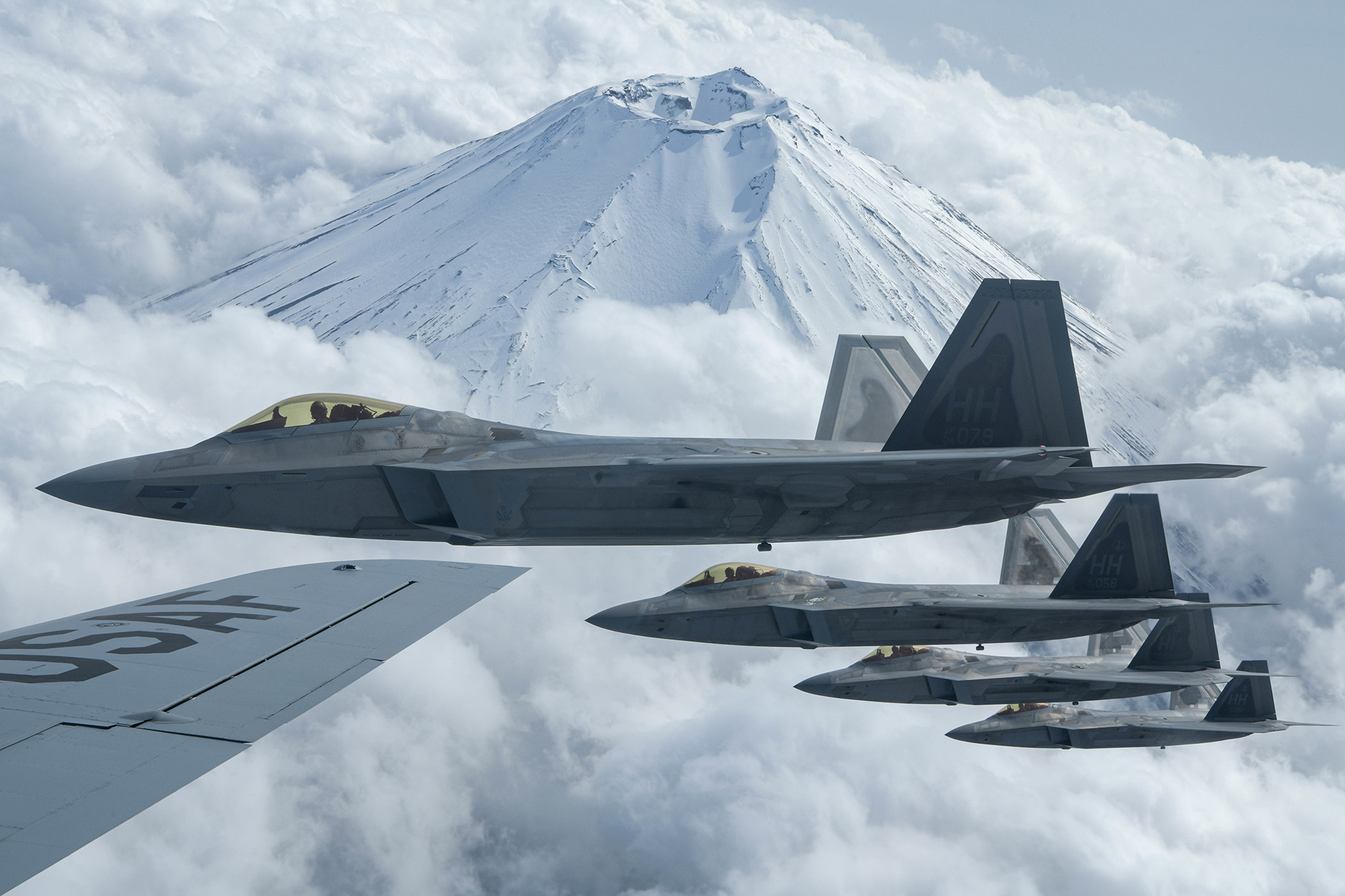Four F-22 Raptors fly alongside a U.S. Air Force KC-135 Stratotanker during fifth-generation fighter training near Mount Fuji, Japan, April 1, 2021. (Senior Airman Rebeckah Medeiros/Air Force)