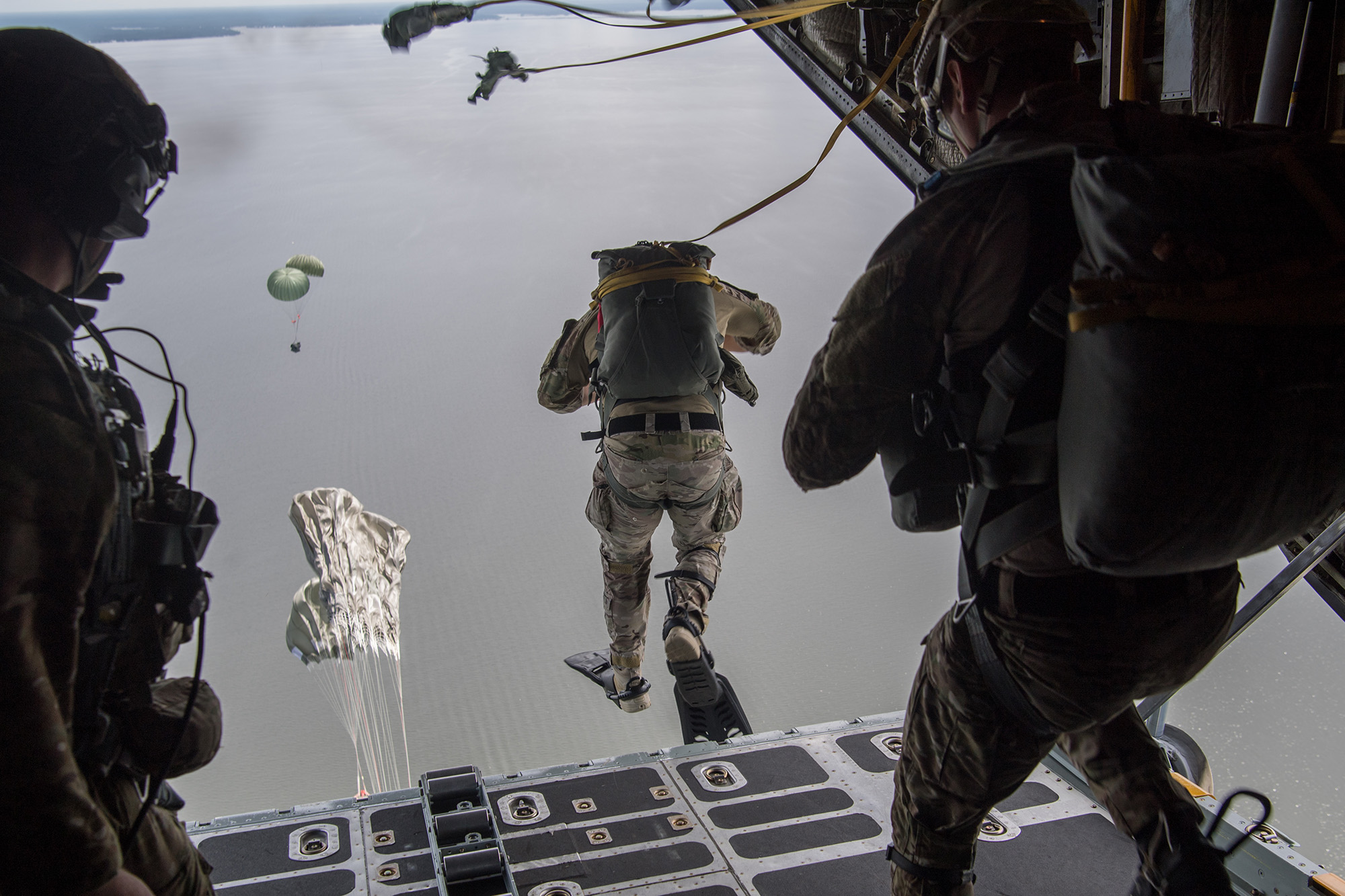 Air Force Special Tactics operators conduct a static line jump out of a C-130H Hercules following a Rigged Alternate Method Boat package into the water during training at Eglin Range, Fla., Aug. 21, 2020. (Tech. Sgt. Rose Gudex/Air Force)