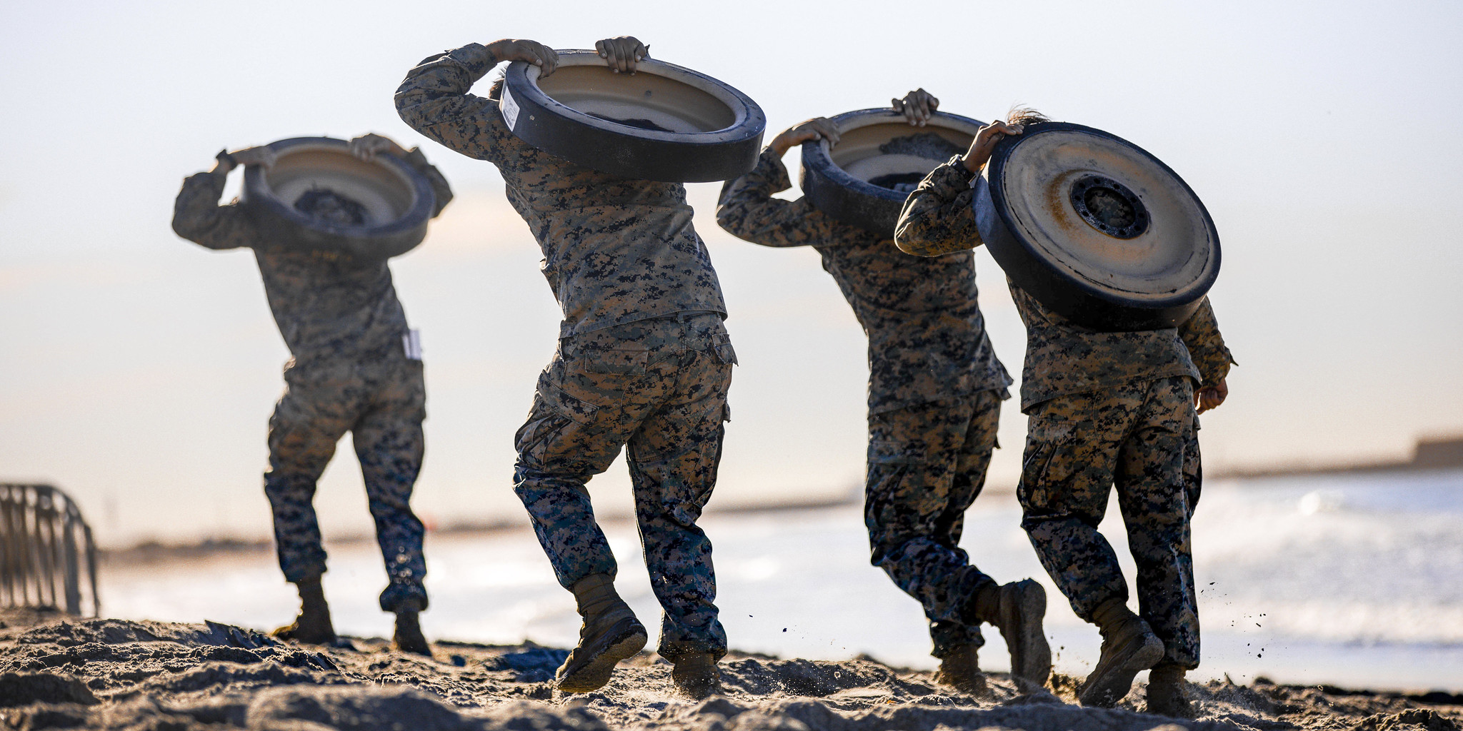 Marines with 1st Marine Division carry track wheels during the Amphibious Combat Endurance Test on Marine Corps Base Camp Pendleton, Calif., Jan. 15, 2021. (Lance Cpl. Roxanna Ortiz/Marine Corps)