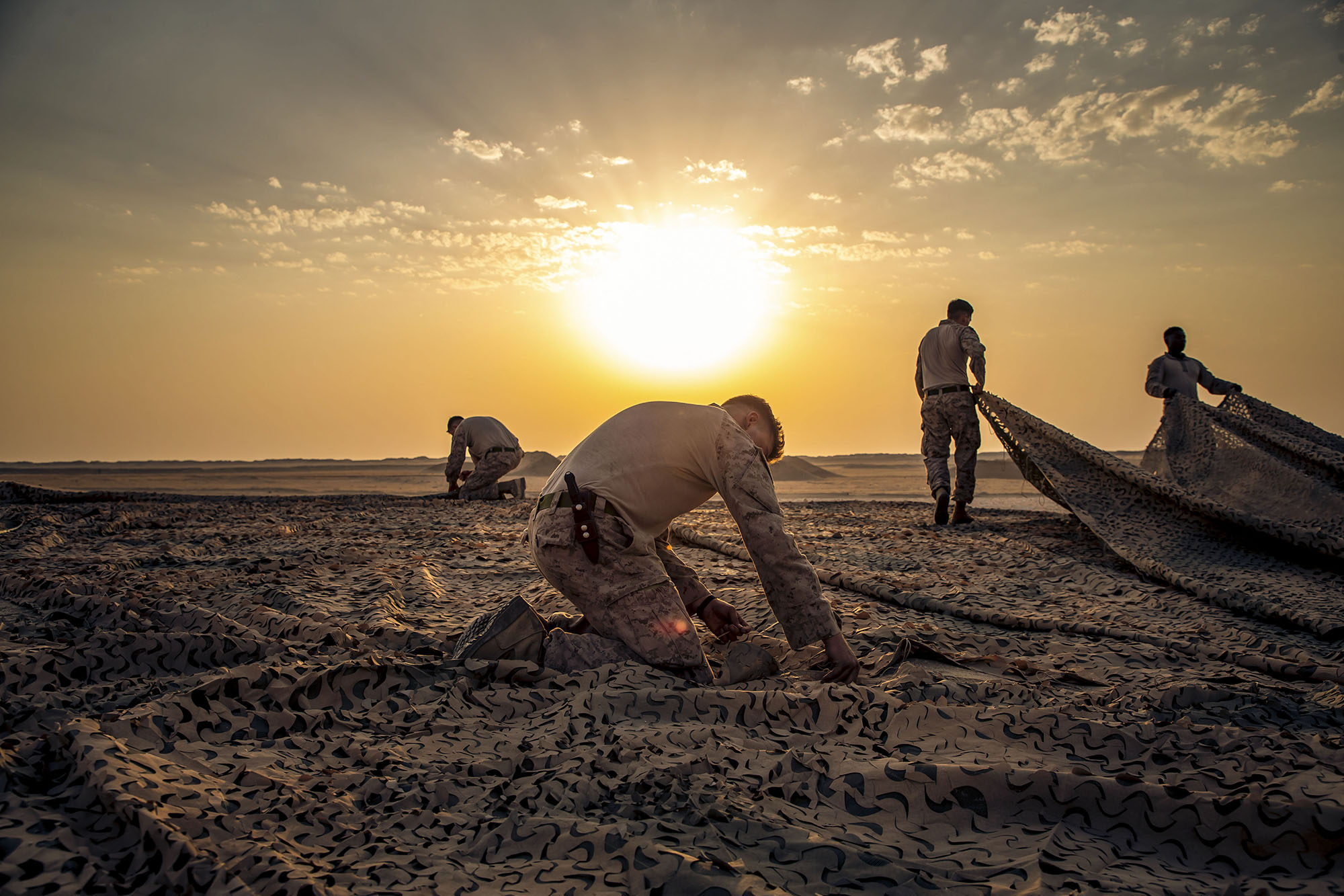 U.S. Marines with Special Purpose Marine Air-Ground Task Force Crisis Response - Central Command 20.2, assemble a camouflage canopy before a demolition range in Kuwait, Aug. 31, 2020. (Lance Cpl. Andrew Skiver/Marine Corps)