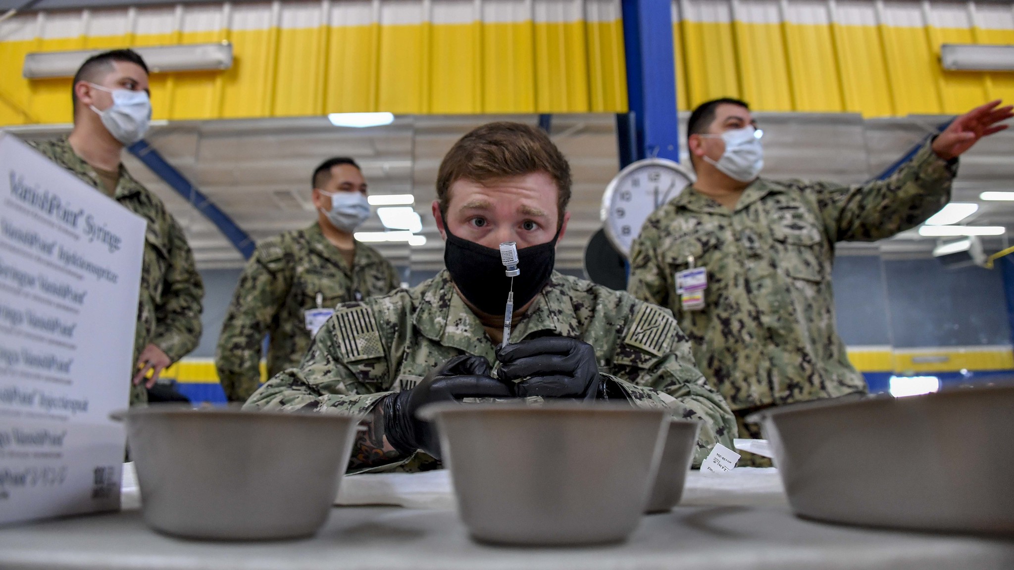 Hospital Corpsman 2nd Class Shane Miller prepares COVID-19 vaccines at the Naval Base San Diego fitness center on Jan. 8, 2020, as part of Operation Warp Speed. (MC1 Julio Rivera/Navy)