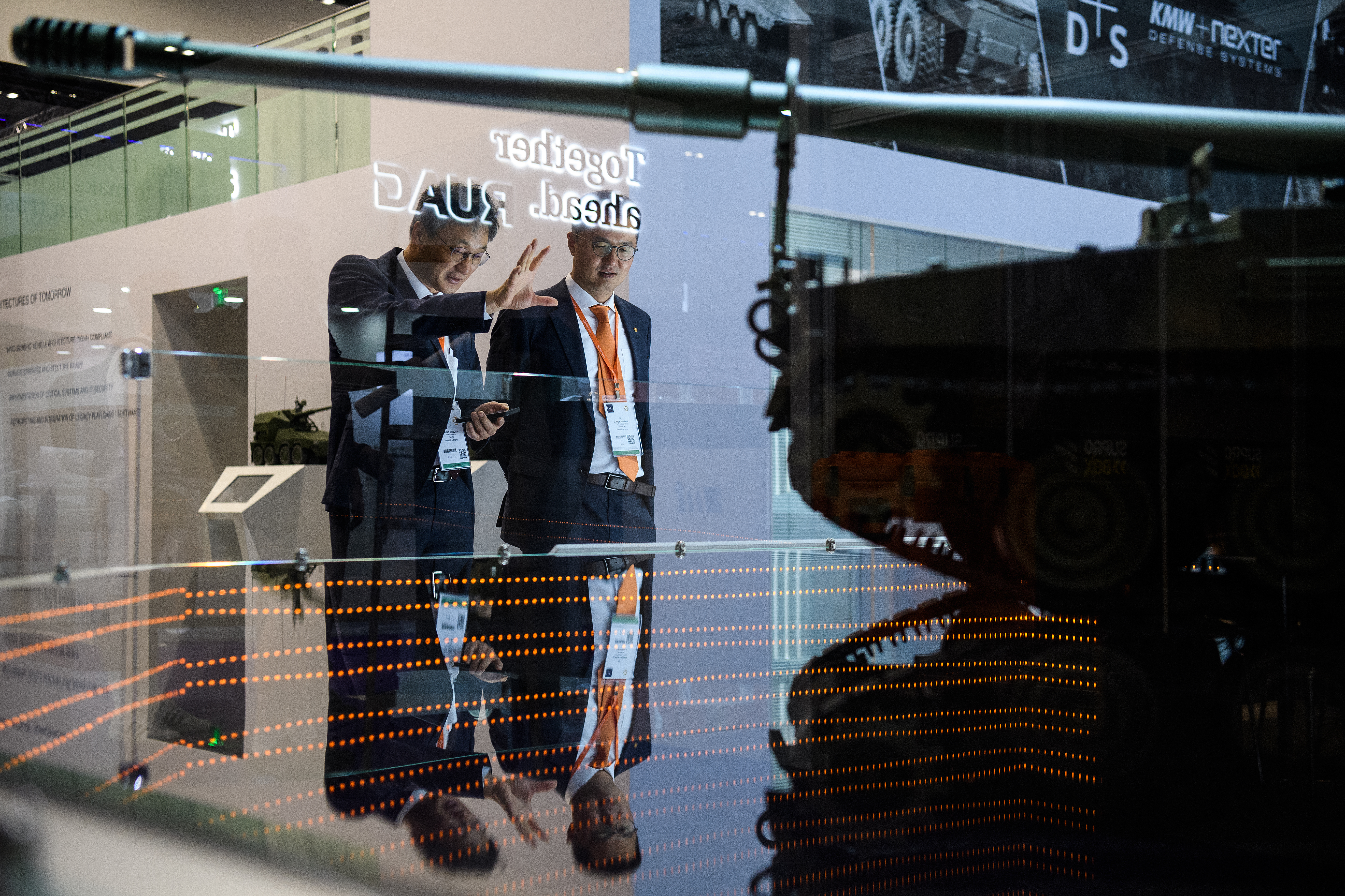 On the second day of the DSEI arms fair, vice president of the Hanwha Group, Byung Chul An, left, looks at a model of the K9 Thunder self-propelled howitzer. (Leon Neal/Getty Images)
