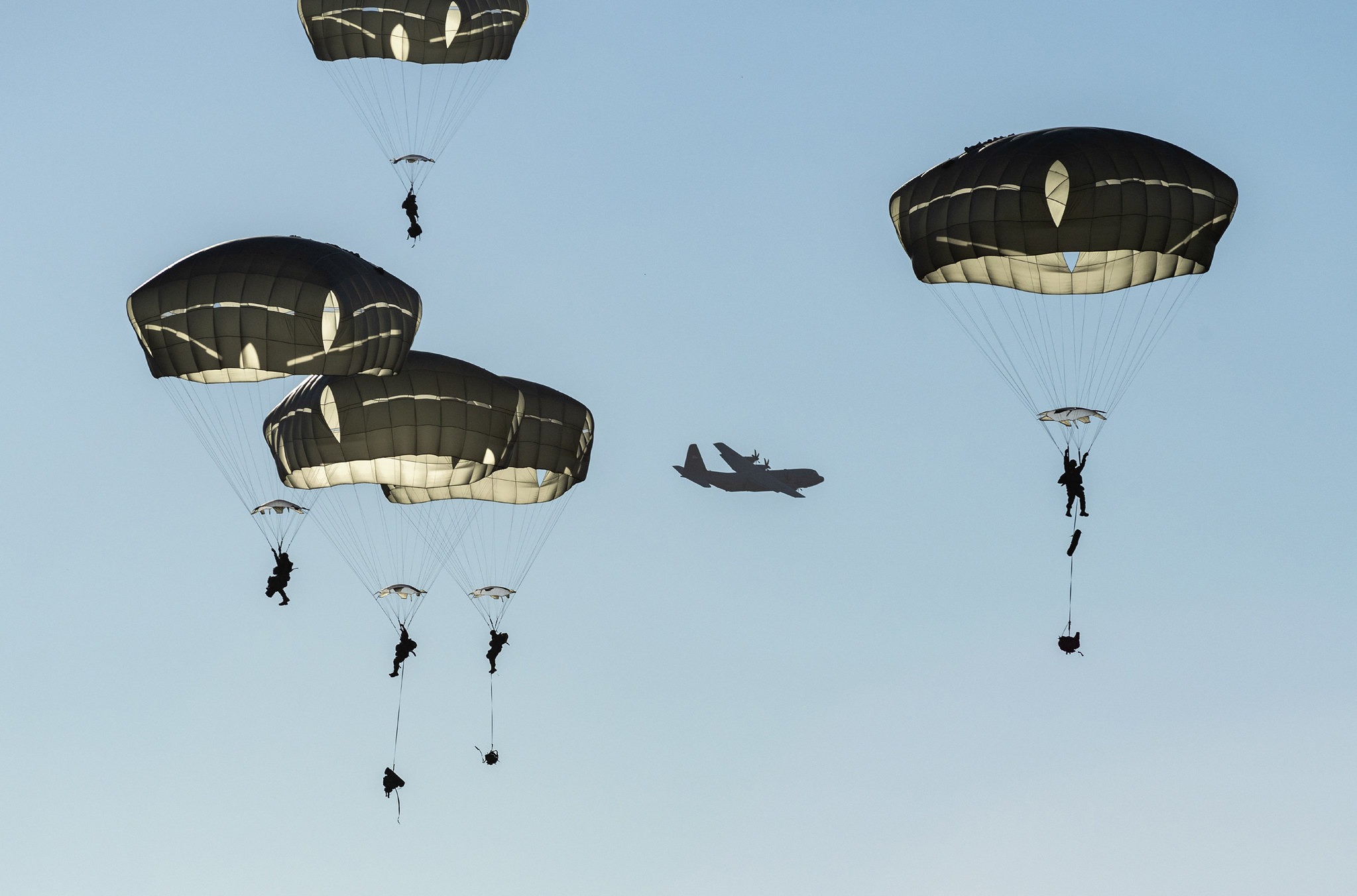 Paratroopers descend over Malemute Drop Zone after jumping from a U.S. Air Force C-130J Super Hercules during airborne training at Joint Base Elmendorf-Richardson, Alaska, Oct. 22, 2020. (Alejandro Pena/Air Force)