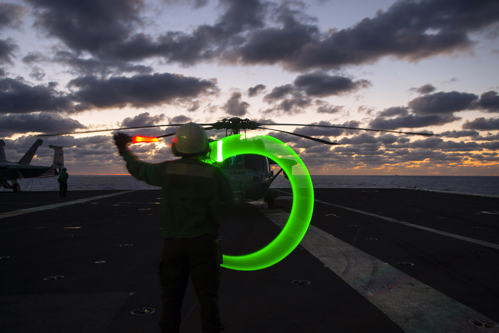 Aviation Structural Mechanic Airman Monica Smith directs a test of an alert helicopter on the flight deck aboard the Nimitz-class aircraft carrier USS Dwight D. Eisenhower (CVN 69), in the Mediterranean Sea, March 19, 2021. (Mass Communication Specialist Seaman Trent P. Hawkins/Navy)