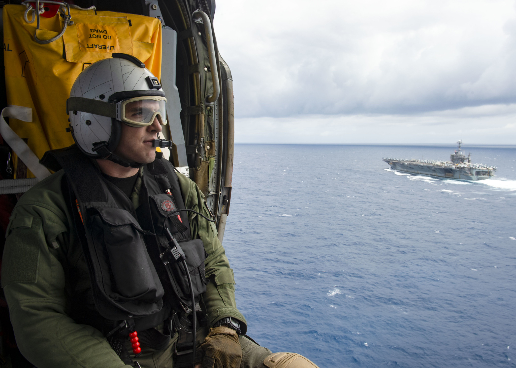 Naval Air Crewman (Helicopter) 3rd Class Jake Shelton observes the Nimitz-class aircraft carrier USS Harry S. Truman (CVN 75) in the Atlantic Ocean on May 27, 2020. (Mass Communication Specialist Seaman Isaac Esposito/Navy)