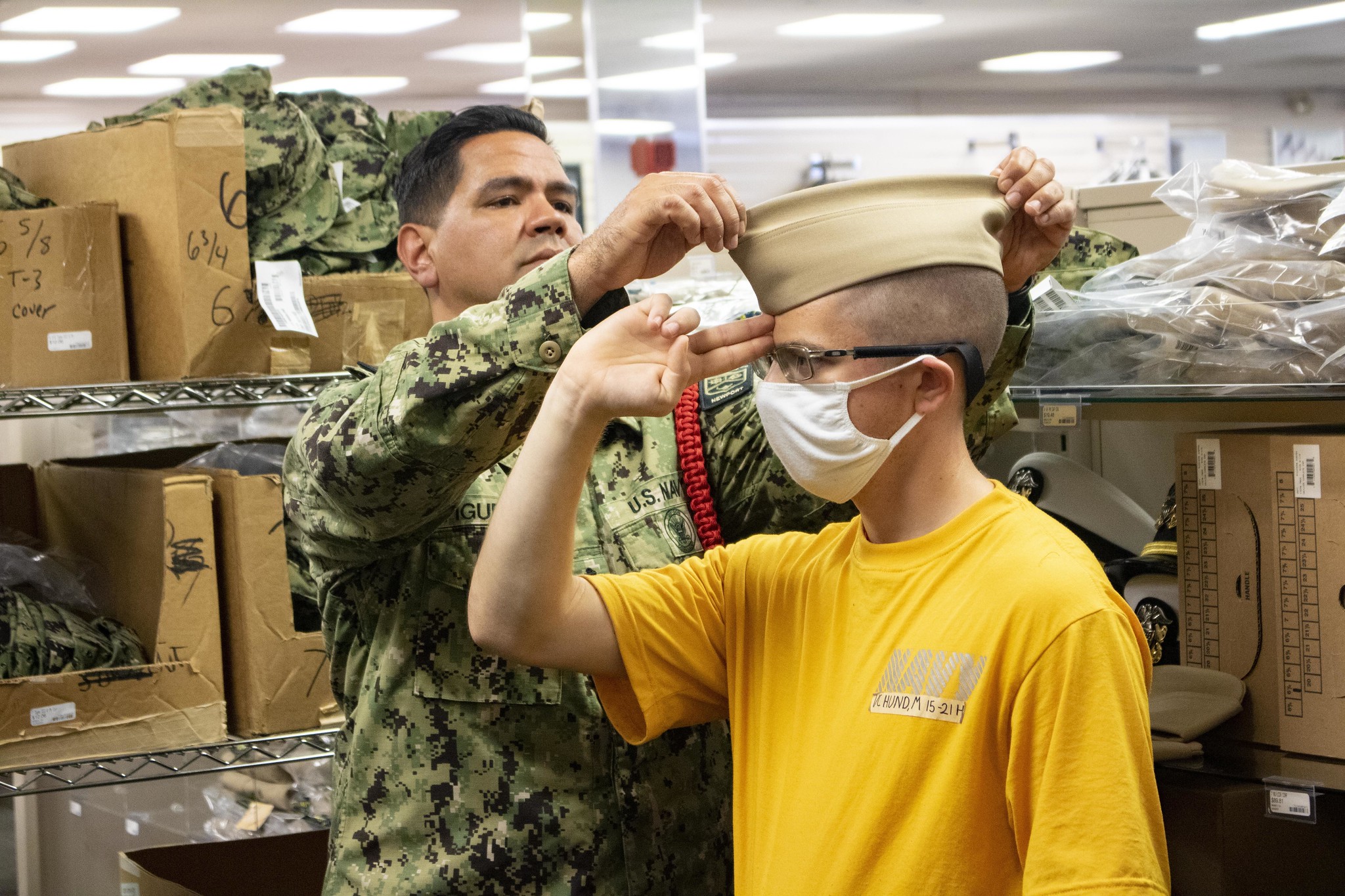 Chief Engineman Alexander Figueroa fits a garrison cover on an Officer Candidate School (OCS) student on June 3, 2021, at Officer Training Command Newport, in Newport, R.I. (Officer Candidate Andrea Perez/Navy)