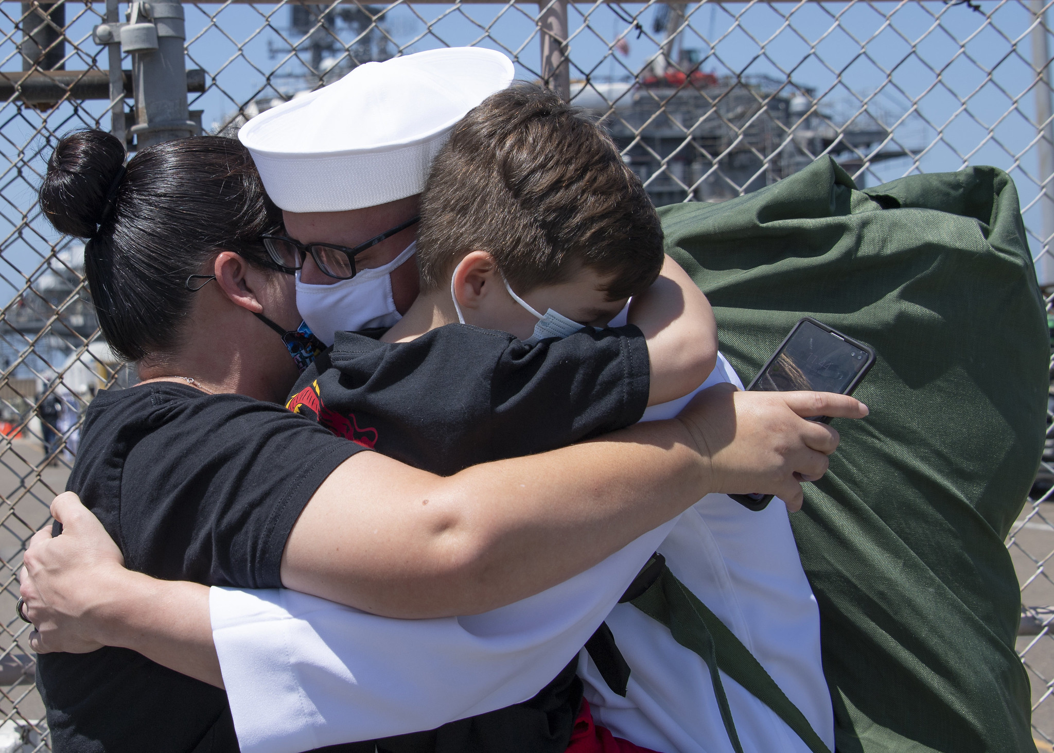Electronics Technician 1st Class Vincent Testagrossa, assigned to the guided-missile destroyer USS Russell (DDG 59), hugs his family following Russell’s return to Naval Base San Diego on July 8, 2020, after a six-month deployment in support of maritime security operations and theater security cooperation efforts in the U.S. 7th Fleet area of operations. (MC3 Kevin C. Leitner/Navy)