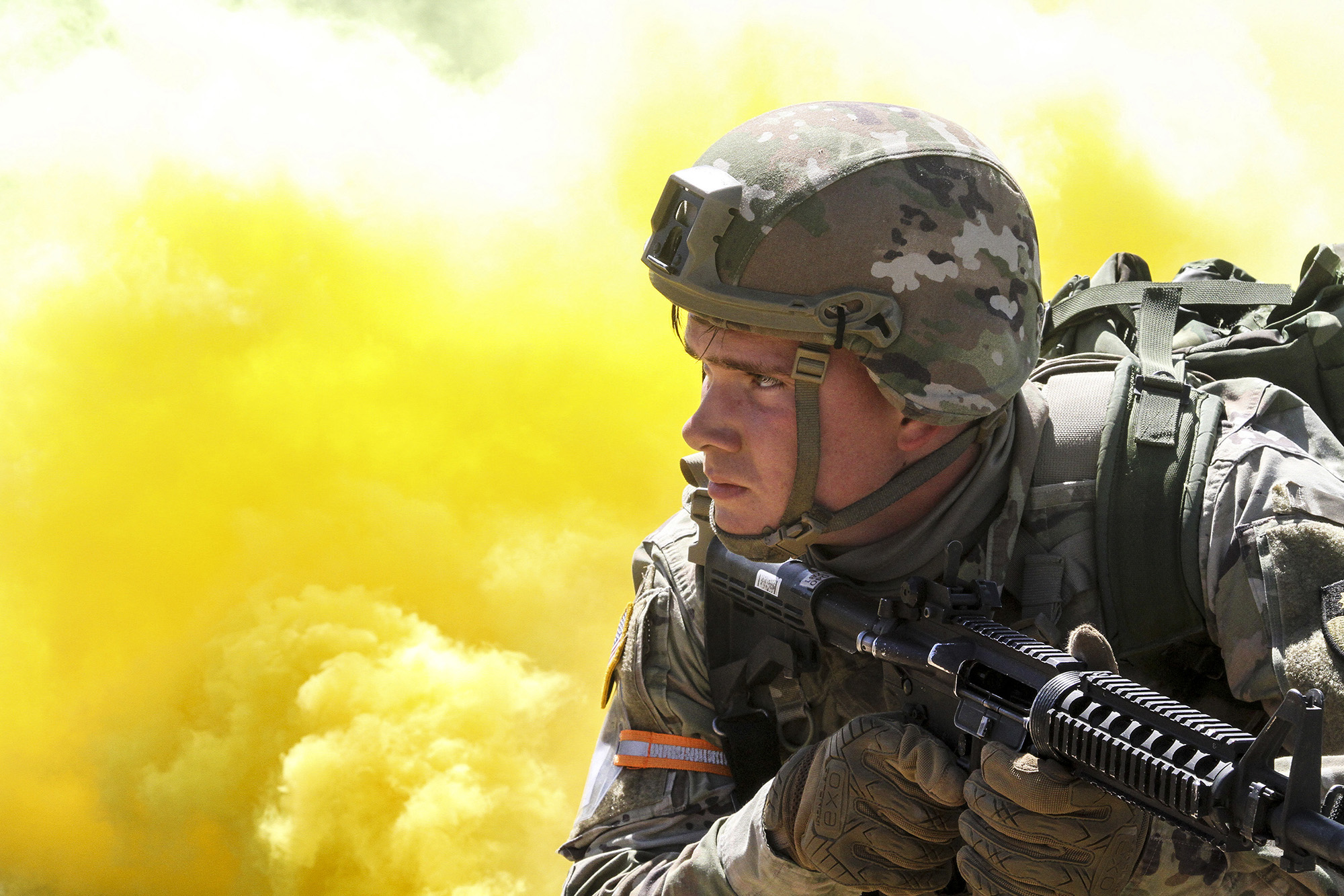 Yellow smoke billows as Spc. Caleb Romero of the California National Guard’s Headquarters Company, 143rd Military Police Battalion, 49th Military Police Brigade, scans his sector March 31, 2021, during the mystery event of Cal Guard's Best Warrior Competition at Camp Roberts, Calif. (Staff Sgt. Eddie Siguenza/Army National Guard)