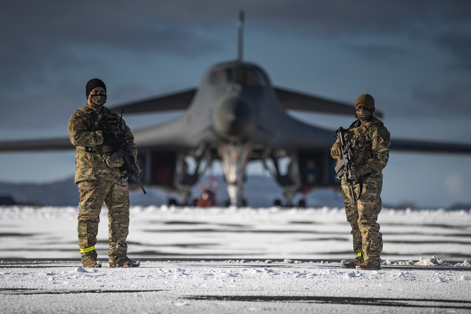 Two defenders assigned to the 7th Security Forces Squadron guard a B-1B Lancer on the flight line at Ørland Air Force Station, Norway, March 7, 2021. (Airman 1st Class Colin Hollowell/Air Force)