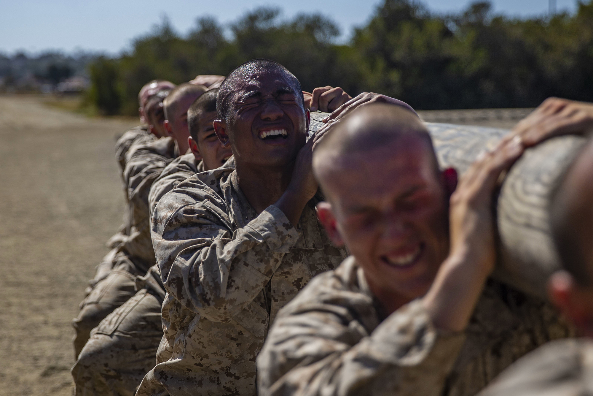 Recruits with Golf Company, 2nd Recruit Training Battalion, execute squats with a log during log drills at Marine Corps Recruit Depot San Diego on May 25, 2021, in California. (Lance Cpl. Grace J. Kindred/Marine Corps)