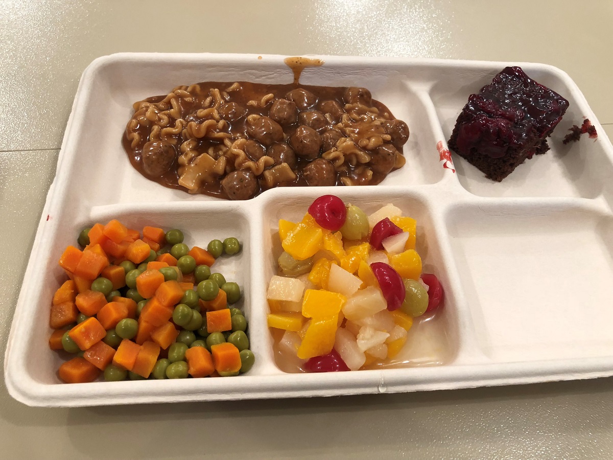 A typical hot lunch of noodles and gravy, fruit cocktail, vegetables, and chocolate cake. The meals were prepared and served by airmen from the 200th RED HORSE Squadron DET 1, Ohio Air National Guard. (Valerie Insinna/Staff)