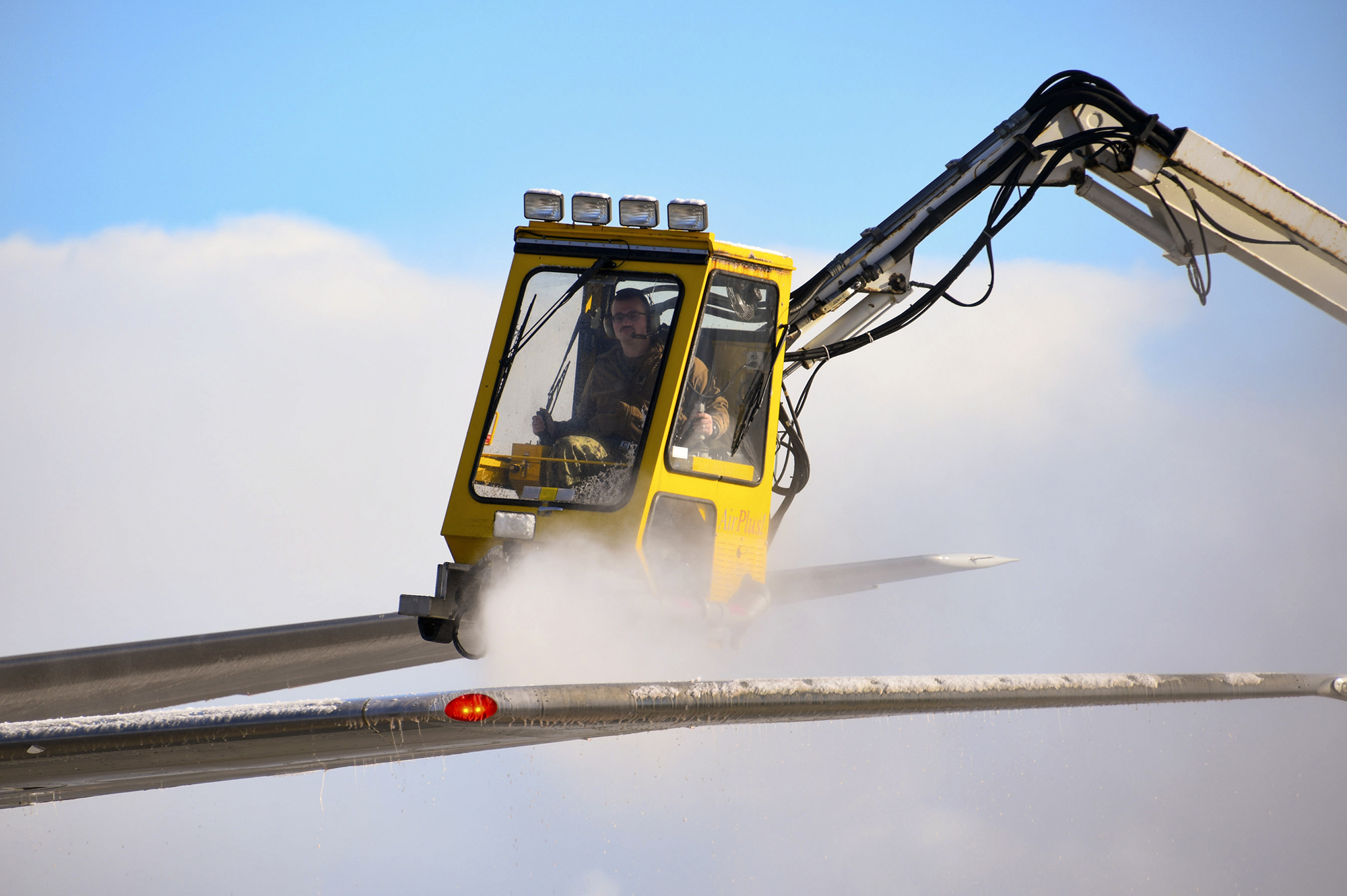 Aviation Machinist’s Mate 1st Class Andrew Sutton operates a de-icing truck to remove snow and ice from the wing of a P-8A Poseidon on Nov. 10, 2020, at Misawa Air Base. (Mass Communication Specialist Seaman Benjamin Ringers/Navy)