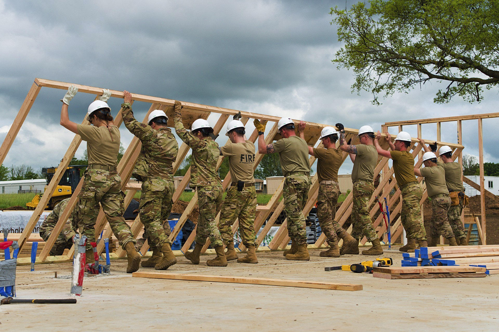 Airmen from all trades, with the 176th Wing’s Civil Engineer Squadron, raise the second exterior wall in unison as they construct the first home in the Cherokee Veterans Housing Initiative in Tahlequah, Okla., May 18, 2021. The initiative is a collaboration between the Department of Defense’s Innovative Readiness Training program and the Cherokee Nation that constructs new single-family homes and supporting infrastructure for eligible Cherokee Nation veterans and their families. (Staff Sgt. Clay Cook/Air National Guard)