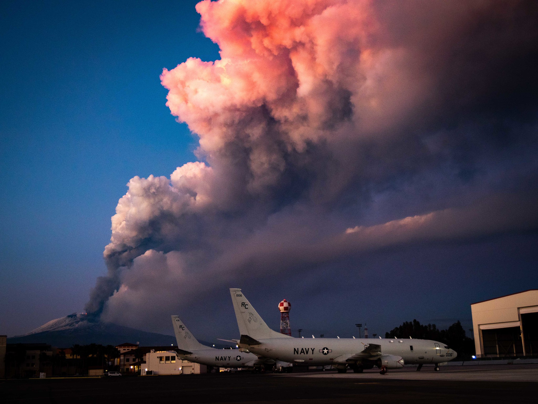 Mount Etna lets off some steam in the background of P-8A Poseidon maritime patrol aircraft Feb. 16, 2021, at Sigonella, Italy. (MC2 Austin Ingram/Navy)