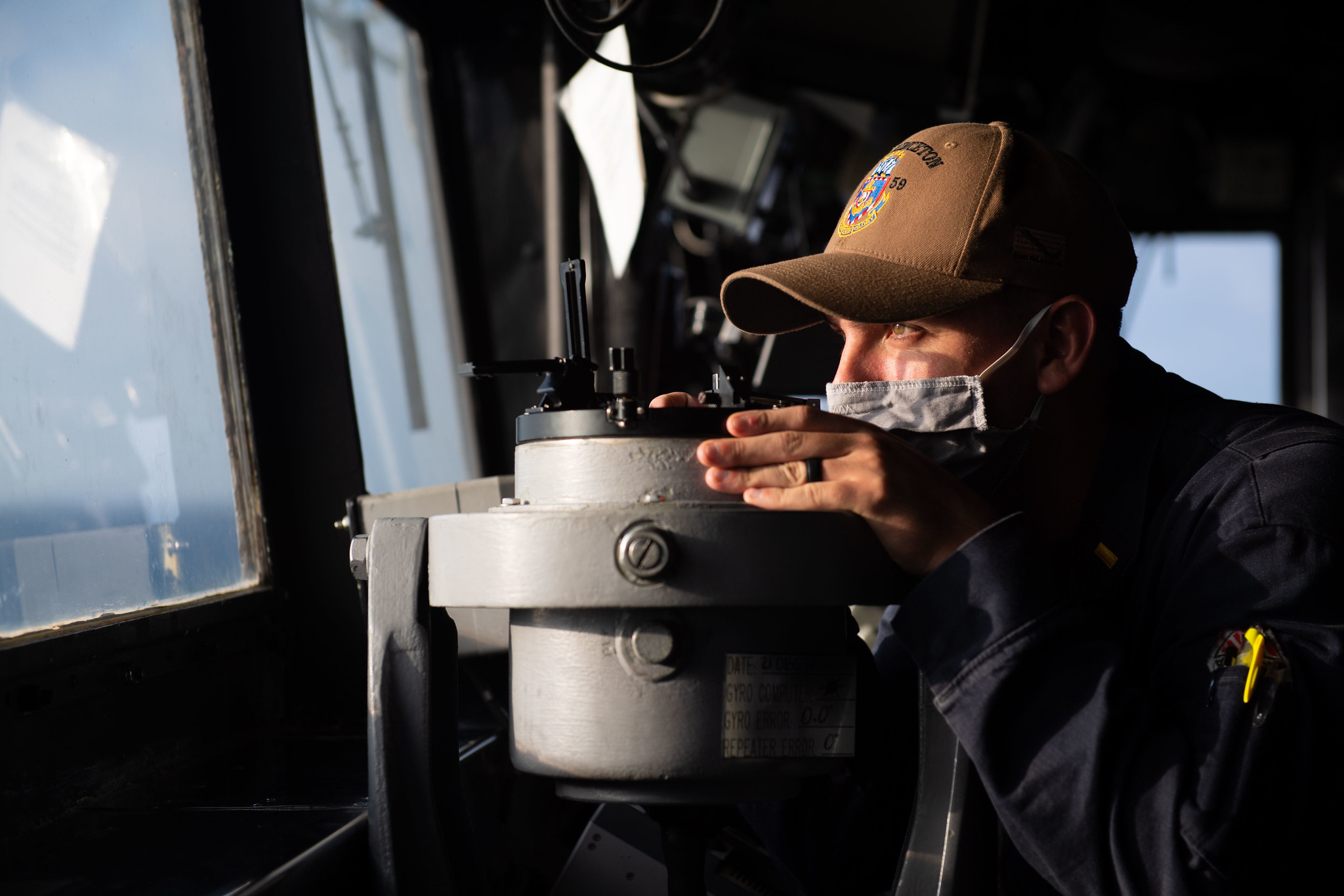 Ensign Chris Luna takes a navigational bearing while standing watch in the pilot house of the guided-missile cruiser USS Princeton (CG 59) on Dec. 21, 2020, in the Indian Ocean. (MC2 Logan C. Kellums/Navy)