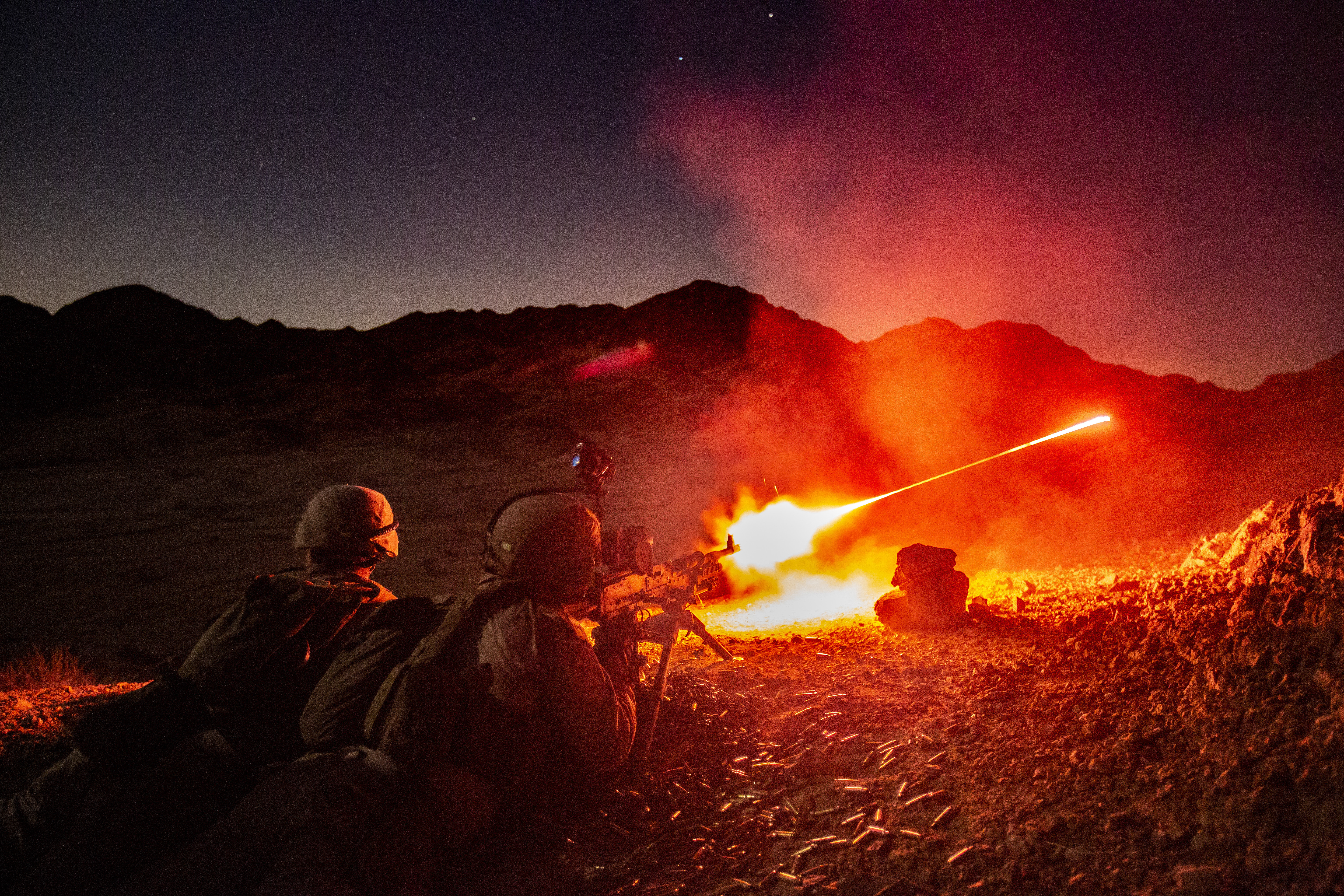 Members of the 24th Marine Expeditionary Unit provide combat support with an M240B medium machine gun while conducting night live-fire platoon assault training at Camp Titin, Jordan, June 21. (1st Lt. Mark Andries/Marine Corps)