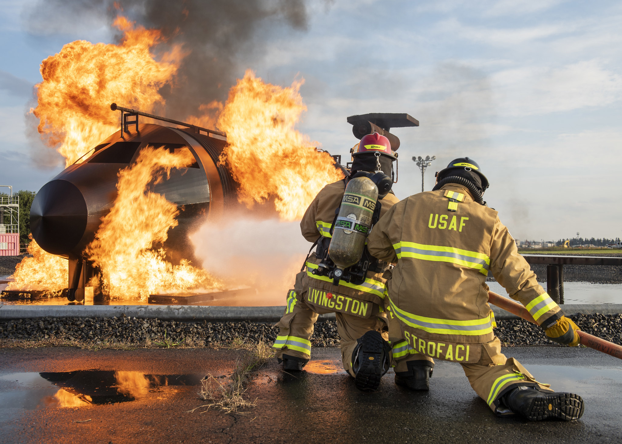 Staff Sgt. Dillon Livingston, left, and Senior Airman Jade Strofaci, 374th Civil Engineer Squadron firefighters, participate in a live-fire training scenario, Oct. 27, 2020, at Yokota Air Base, Japan. (Staff Sgt. Juan Torres/Air Force)
