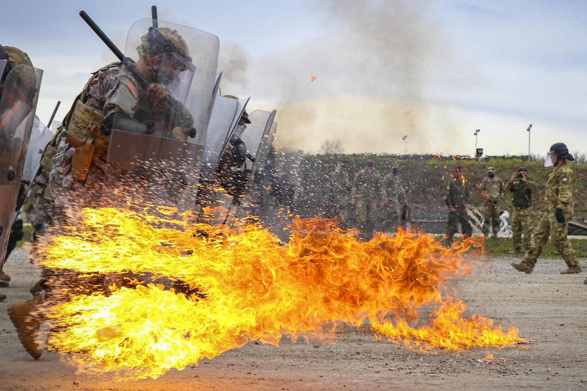Iowa Army National Guardsmen run through a spray of gasoline and flames during fire phobia training at Camp Novo Selo, Kosovo, April 13, 2021. (Staff Sgt. Tawny Schmit/U.S. Army)