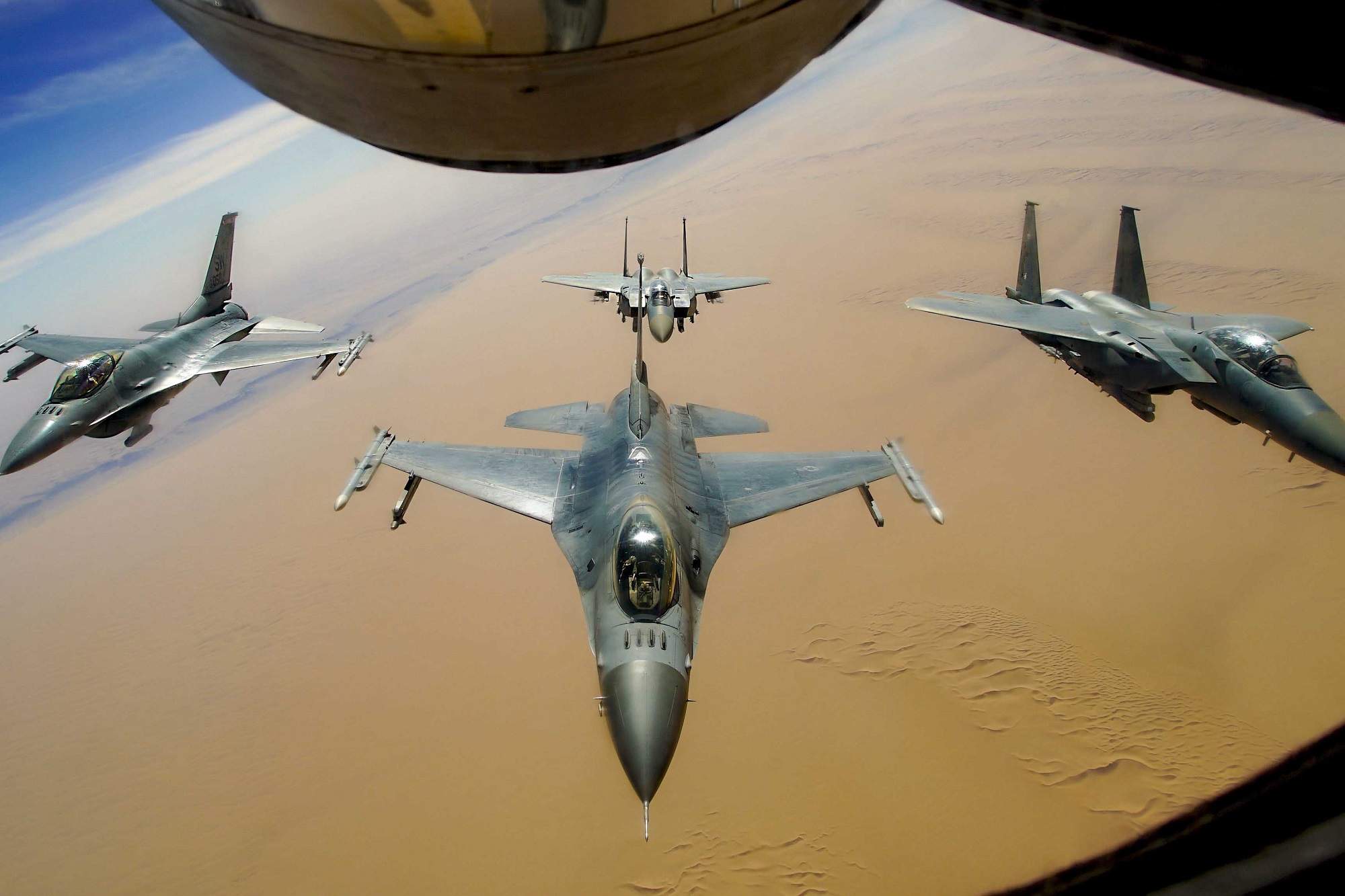 Two U.S. Air Force F-16 Fighting Falcons fly in formation with two Royal Saudi Air Force F-15E Strike Eagles after receiving fuel from a KC-135R Stratotanker during a routine exercise over Southwest Asia, Dec. 15, 2020. (Staff Sgt. Taylor Harrison/Air Force)