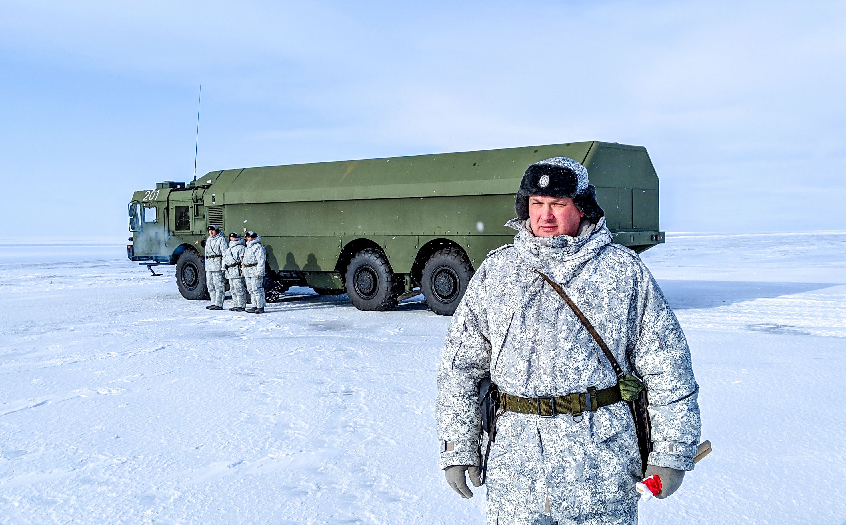 A Russian officer, right, and soldiers stand next to a special military truck at the Russian northern military base on Kotelny island, beyond the Arctic Circle on April 3, 2019. The Russian military base dubbed the 