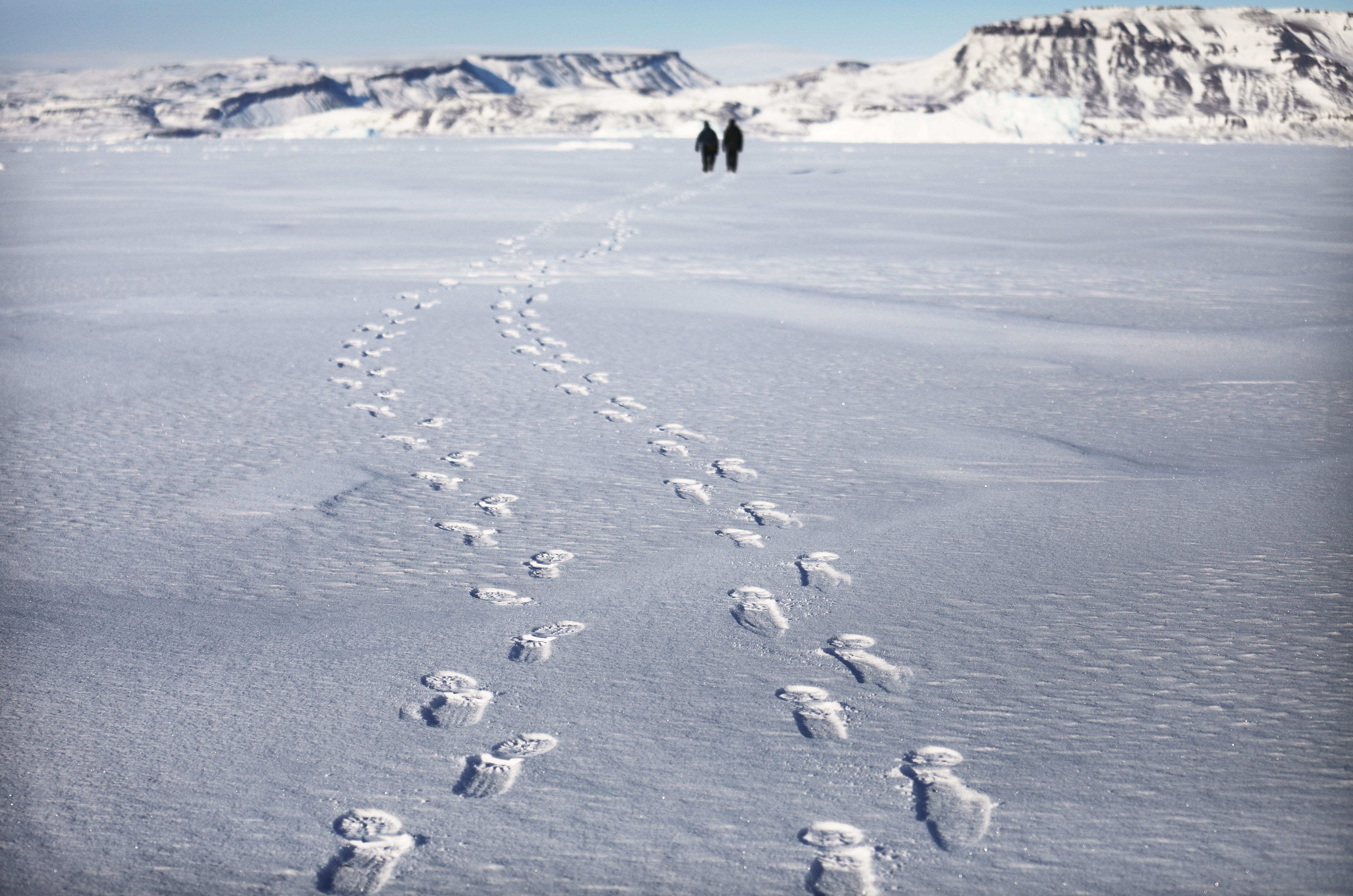 Project scientist Nathan Kurtz and senior support scientist Jeremy Harbeck walk on their way to survey an iceberg locked in sea ice near Thule Air Base on March 26, 2017, in Pituffik, Greenland. NASA's Operation IceBridge was flying research missions out of the base and other Arctic locations. IceBridge team members took the rare opportunity to survey sea ice near the base from the ground. Thule Air Base is the U.S. military's northernmost base located some 750 miles above the Arctic Circle. (Mario Tama/Getty Images)