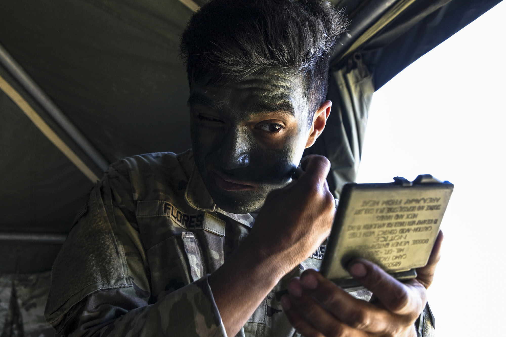 Army Spc. Christian Flores applies face paint prior to mission during the U.S. Army Europe European Best Warrior Competition at U.S. Army Garrison Hohenfels Training Area, Germany, July 29, 2020. (Spc. Austin Riel/Army)